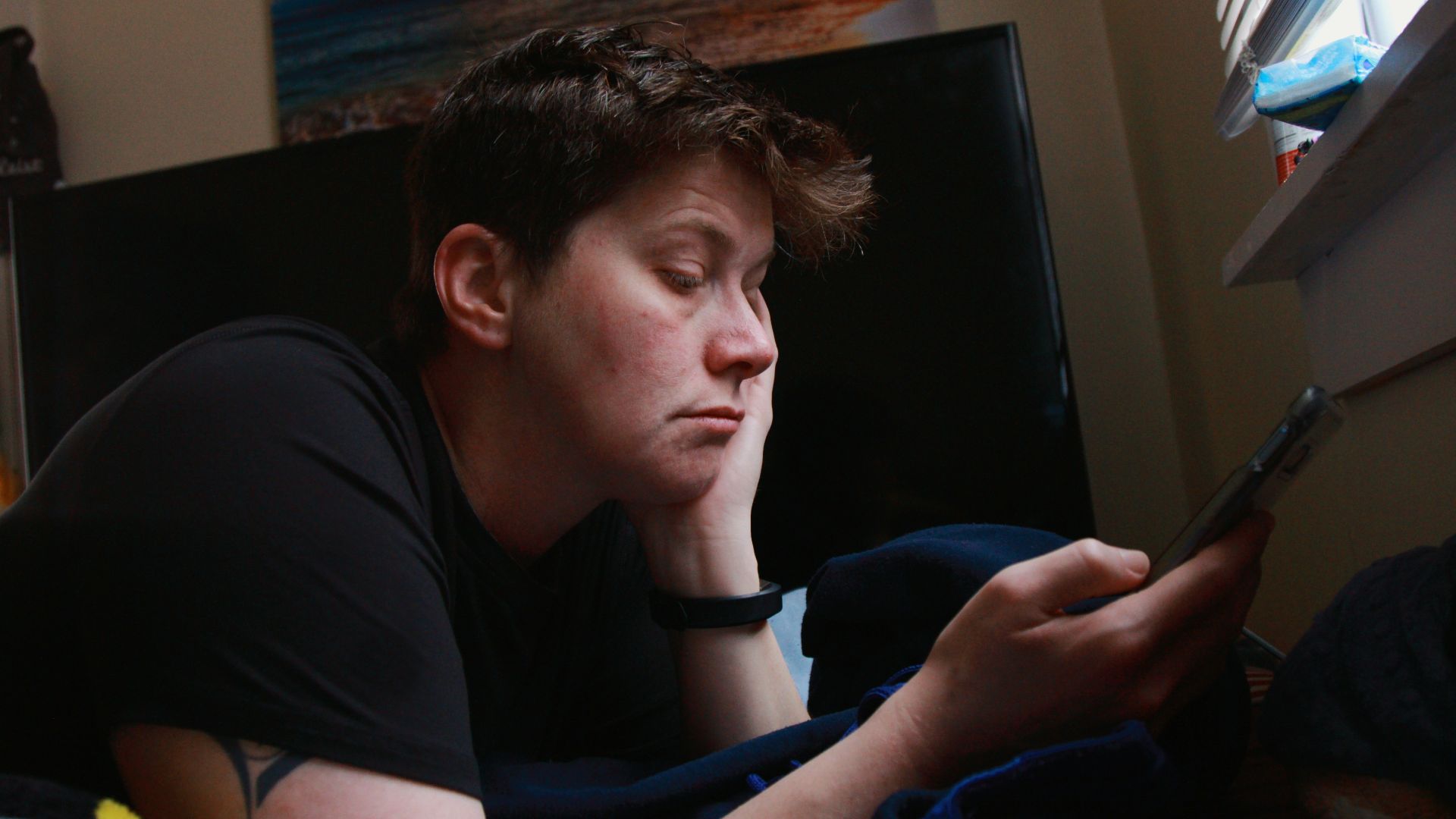 man in black crew neck t-shirt holding black smartphone