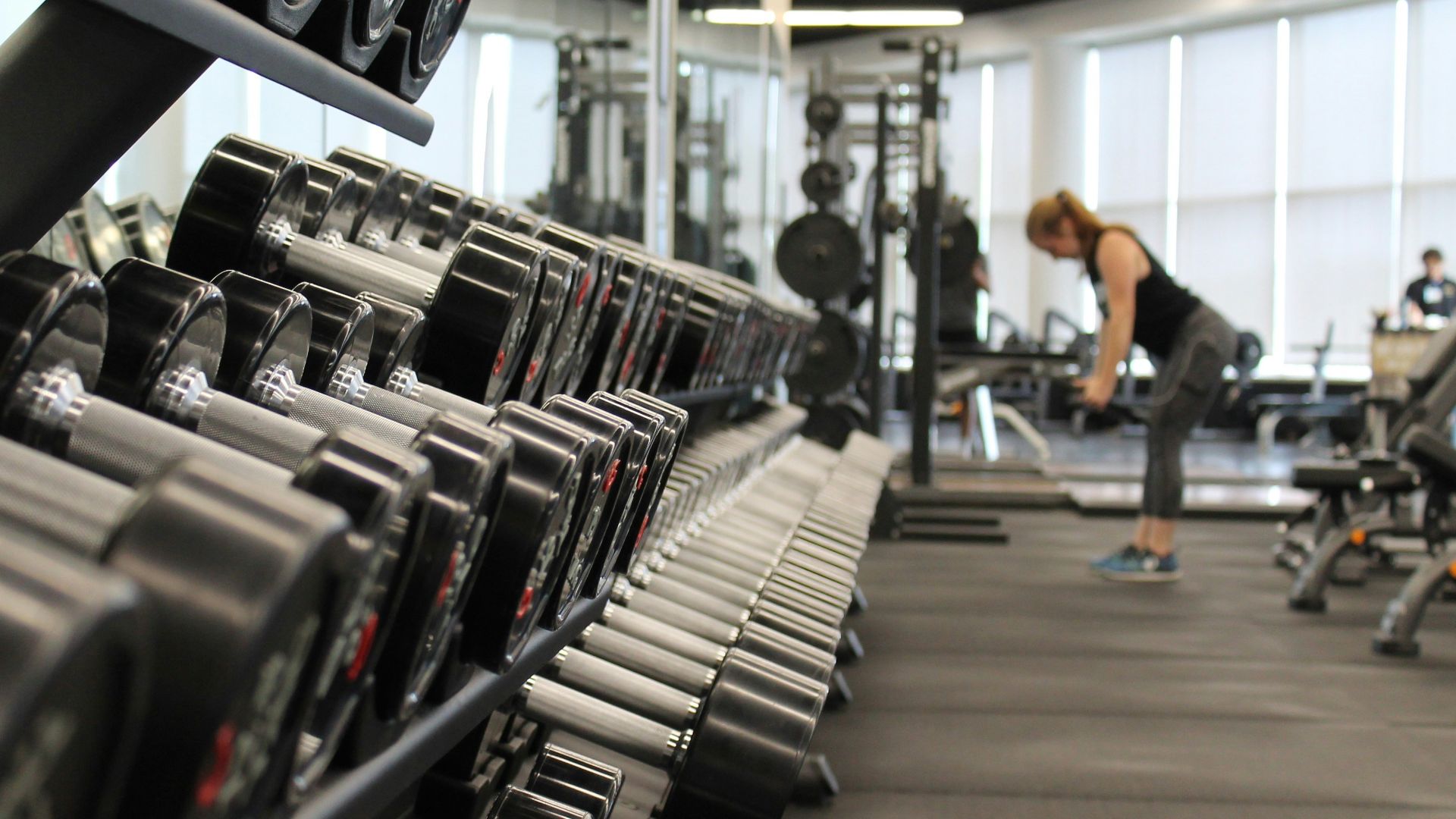 woman standing surrounded by exercise equipment