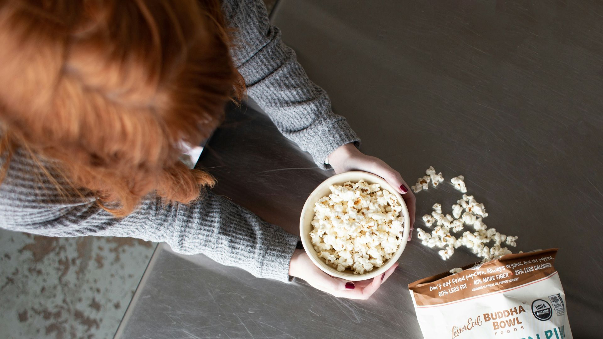 woman holding bowl of popcorn