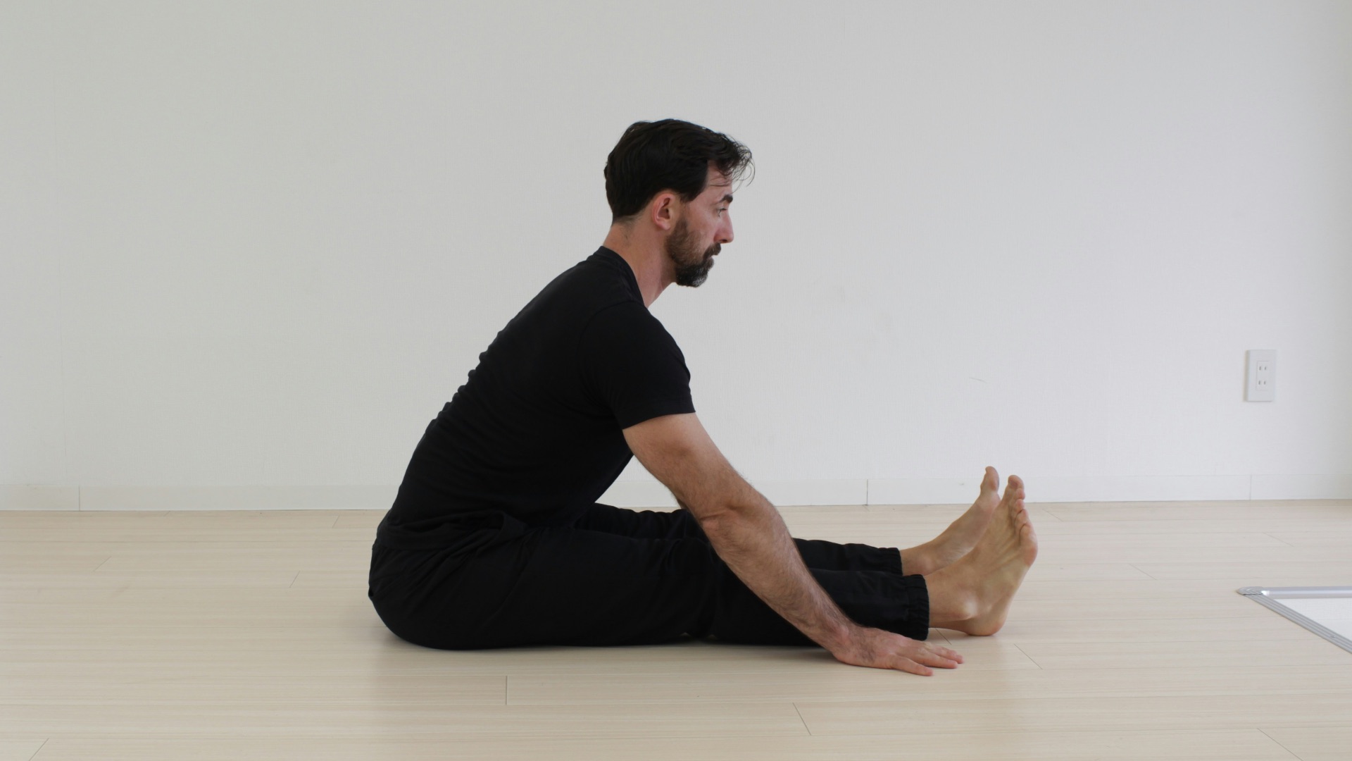 a man sitting on the floor in a white room