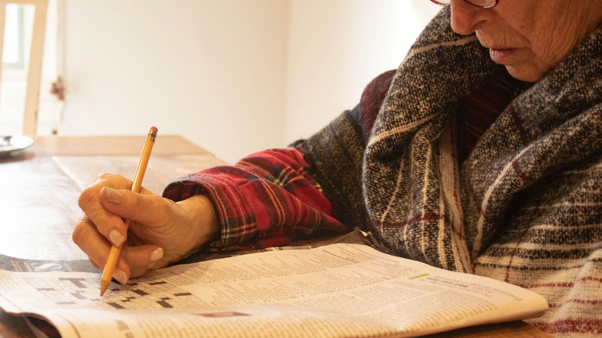 person in black and white sweater writing on white paper