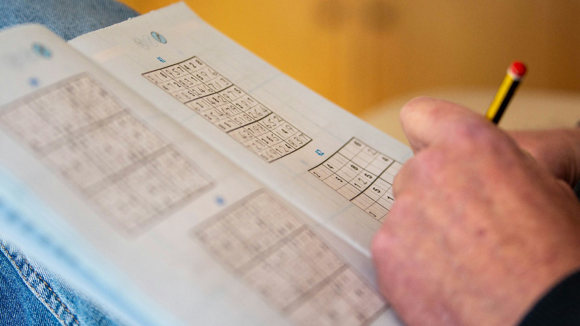 a person is holding a piece of paper with numbers on it