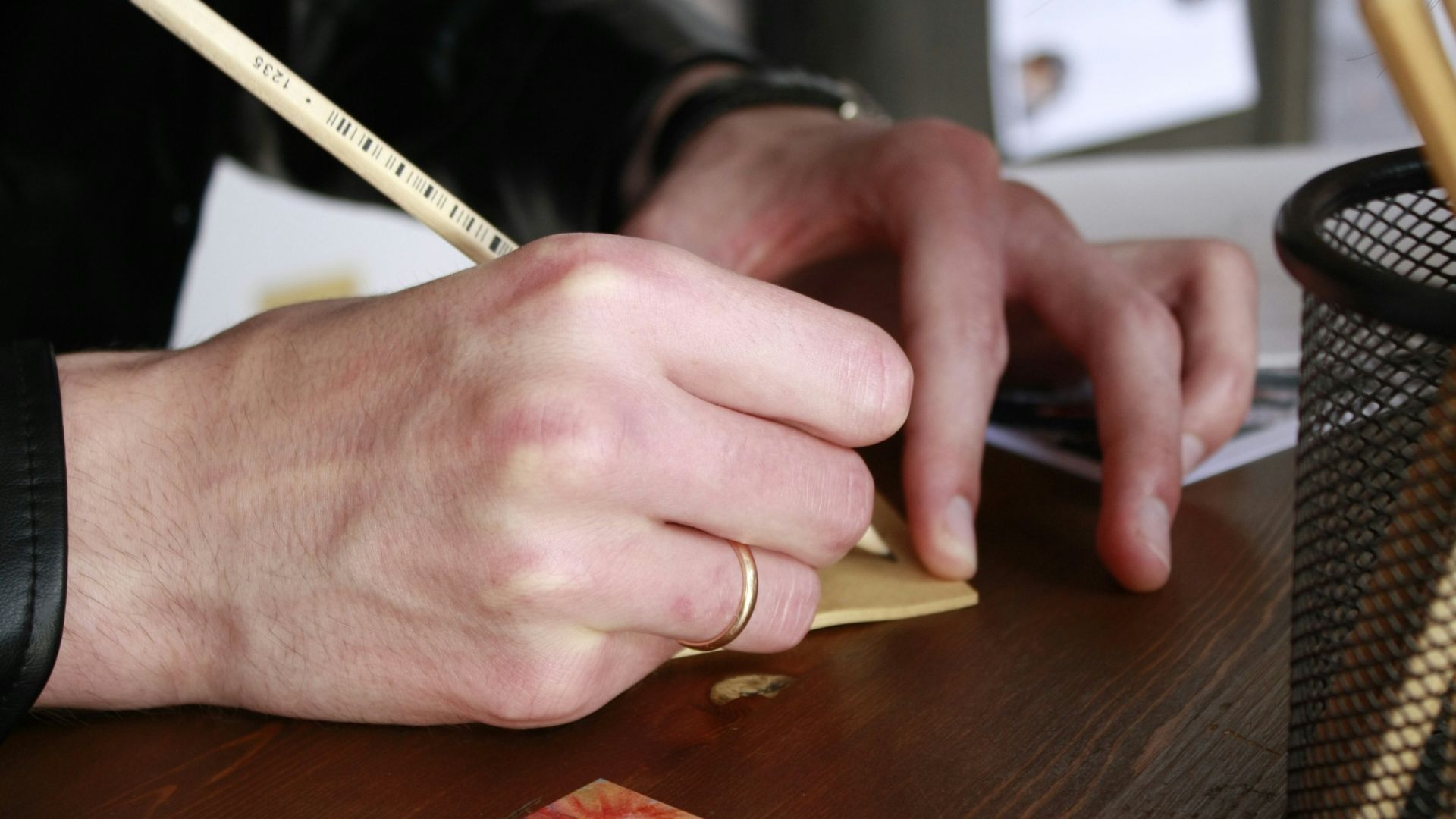 A person sitting at a desk writing on a piece of paper