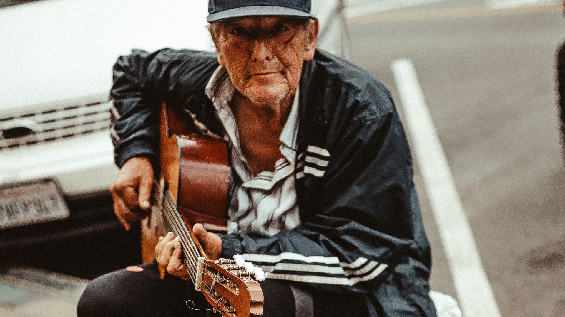 man playing guitar while sitting