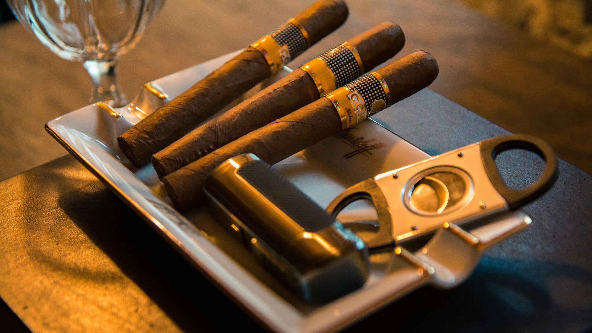 three cigar beside cutter on ashtray