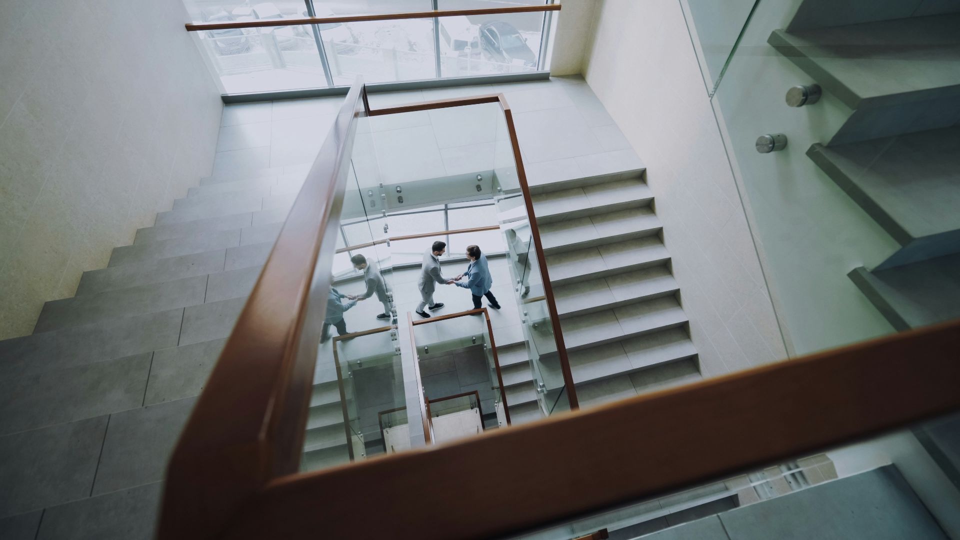 Three people climbing stairs in a modern building