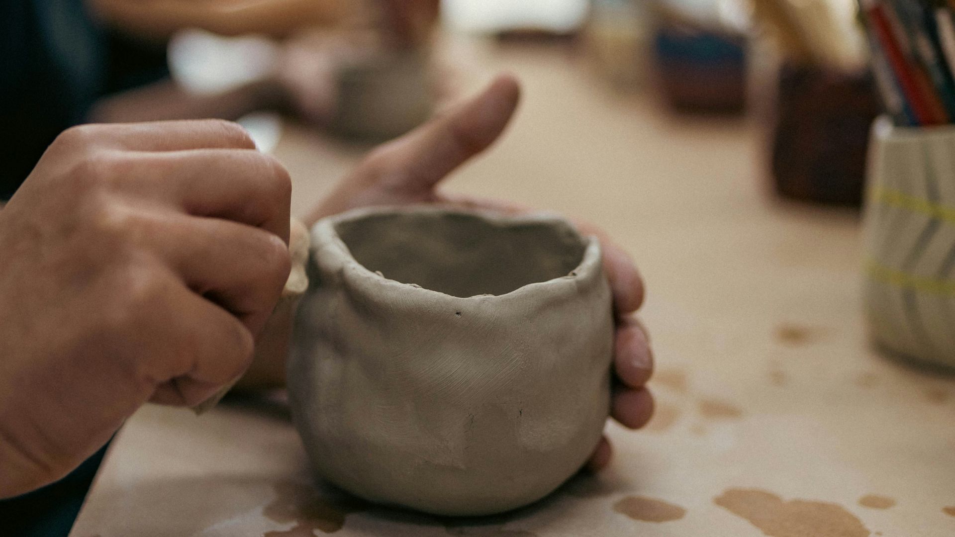 A person sitting at a table with a cup in front of them