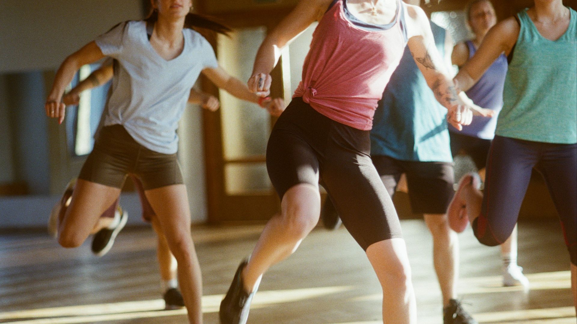group of women running on brown wooden floor