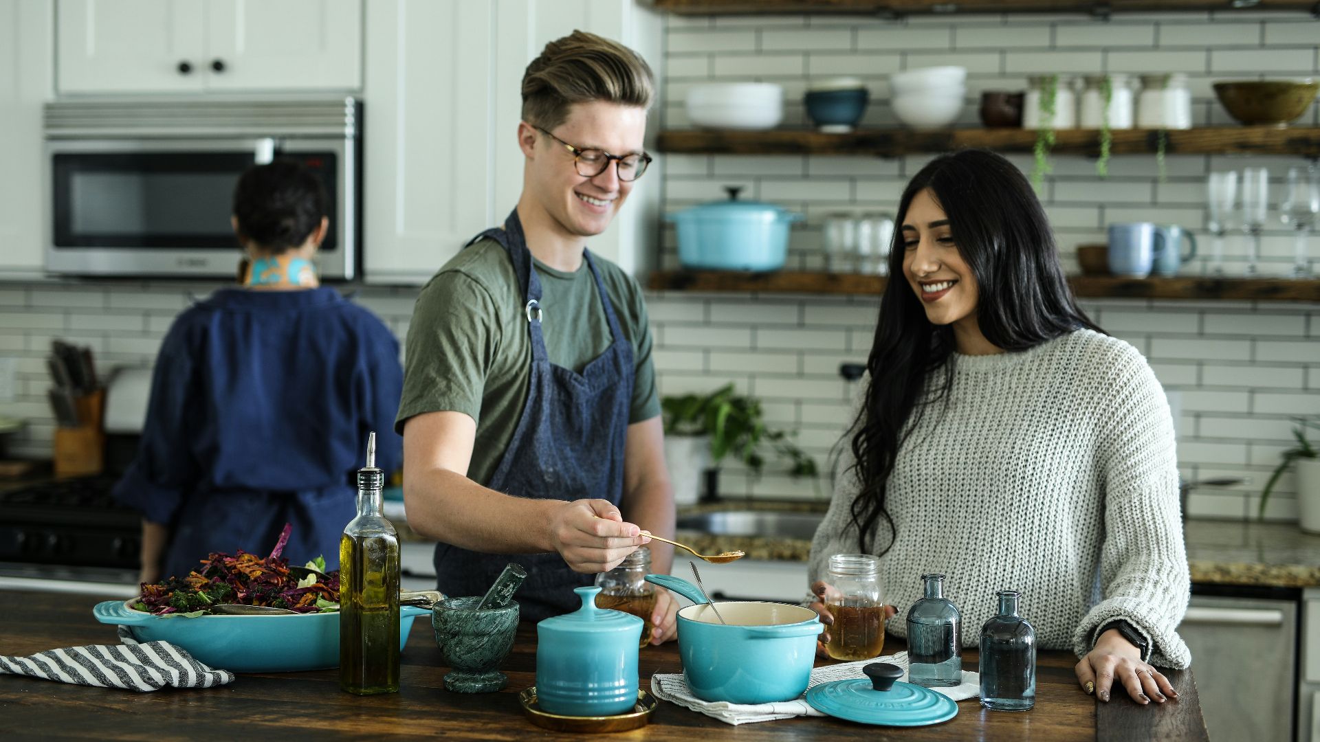 smiling man standing and mixing near woman in kitchen area of the house