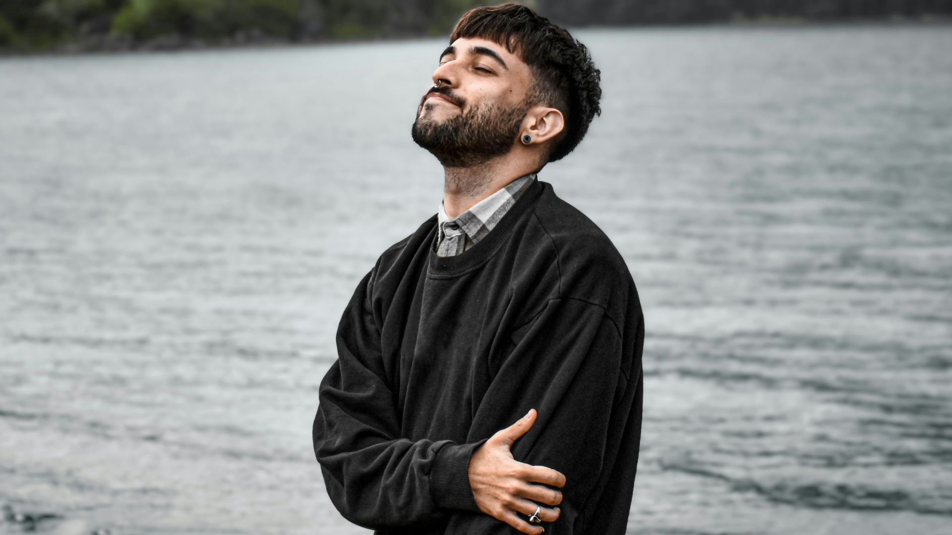 a man standing on a beach next to a body of water