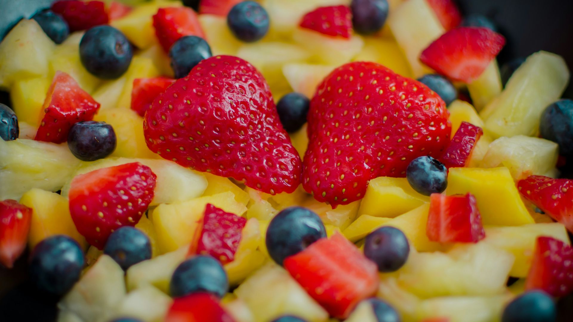 red strawberries on black ceramic bowl