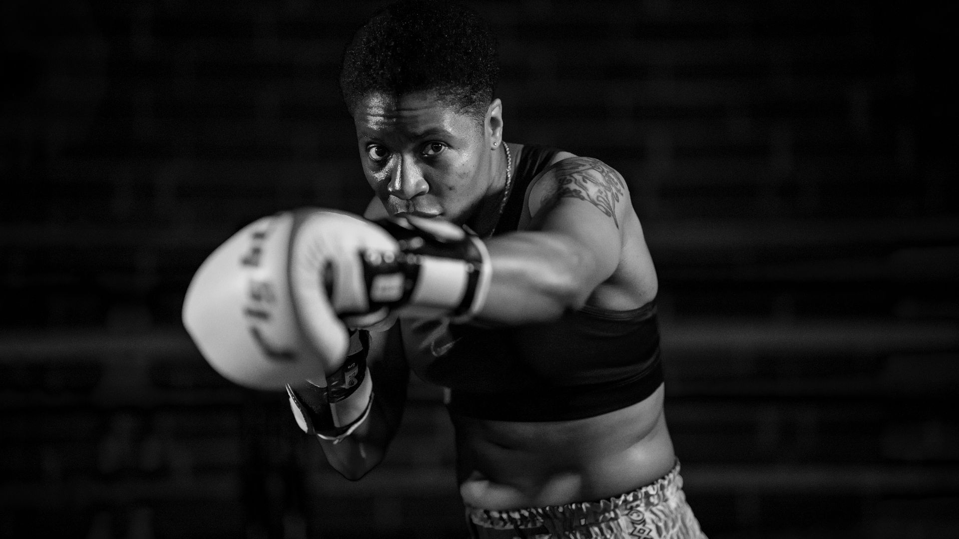 grayscale photo of woman in boxing gloves