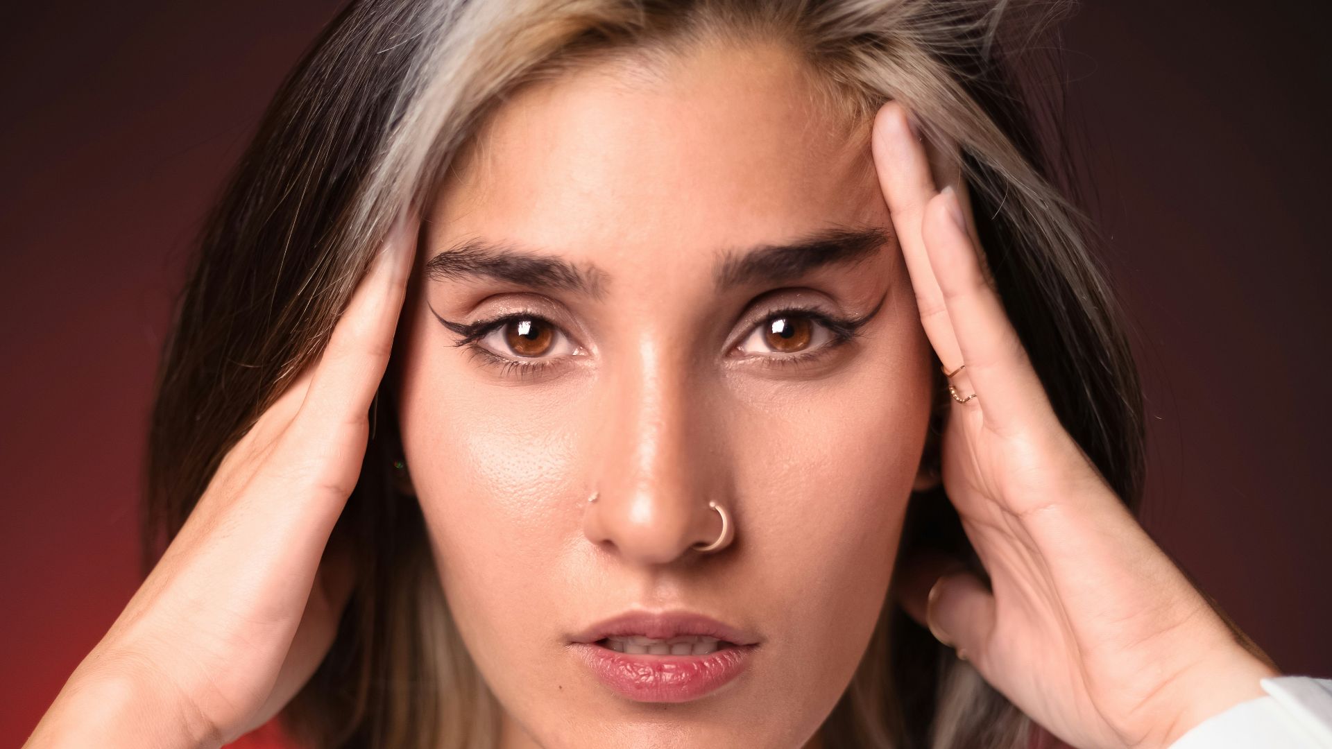 a woman holding her hands to her head