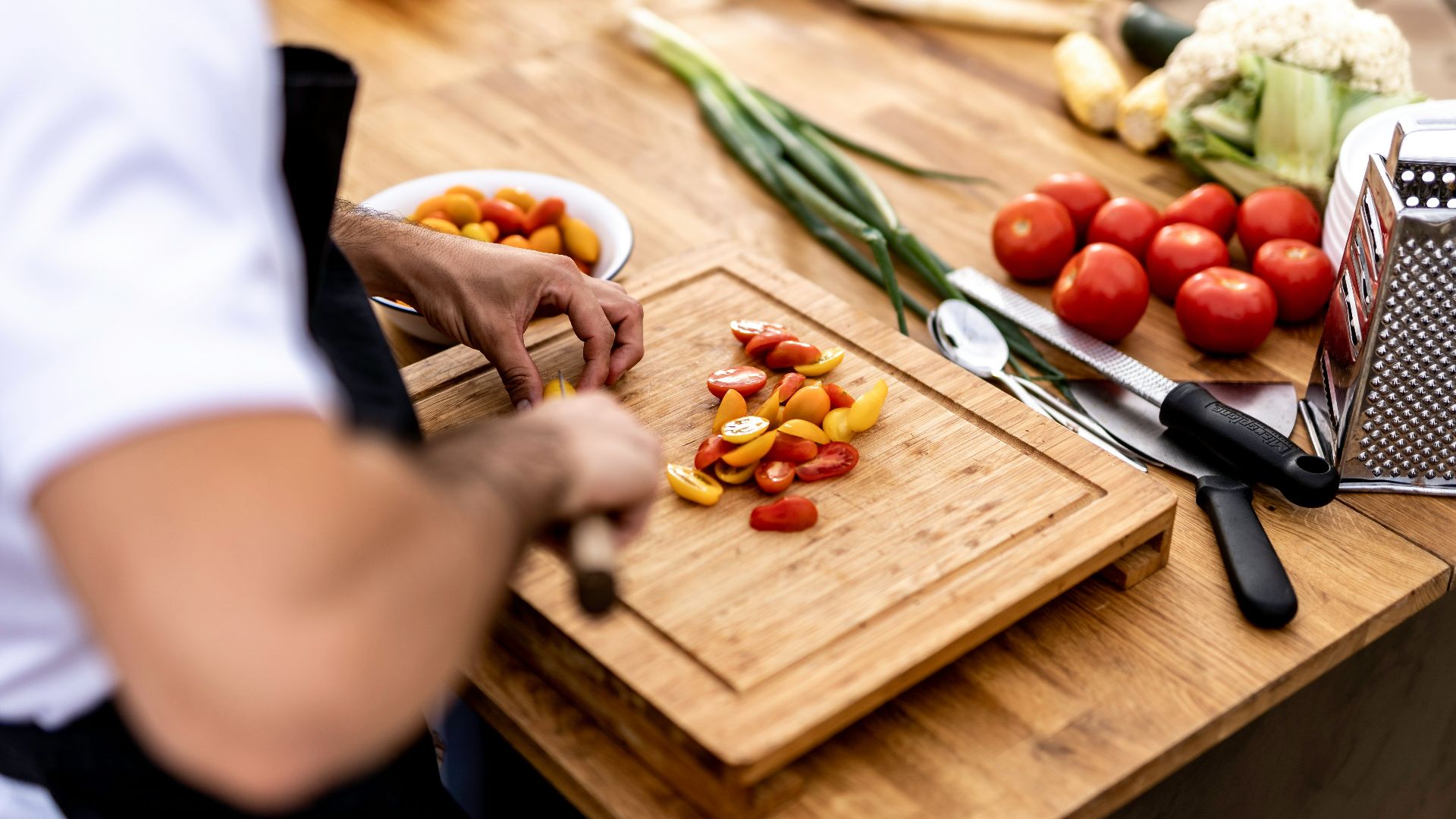 a person cutting up vegetables on a cutting board