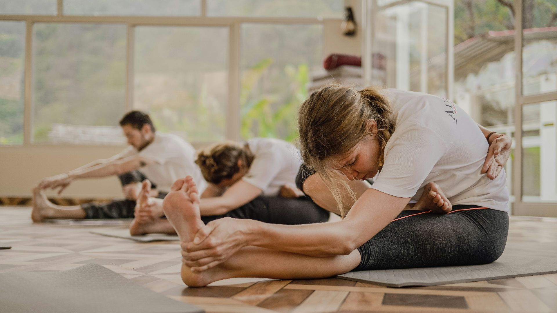 a group of people doing yoga in a room