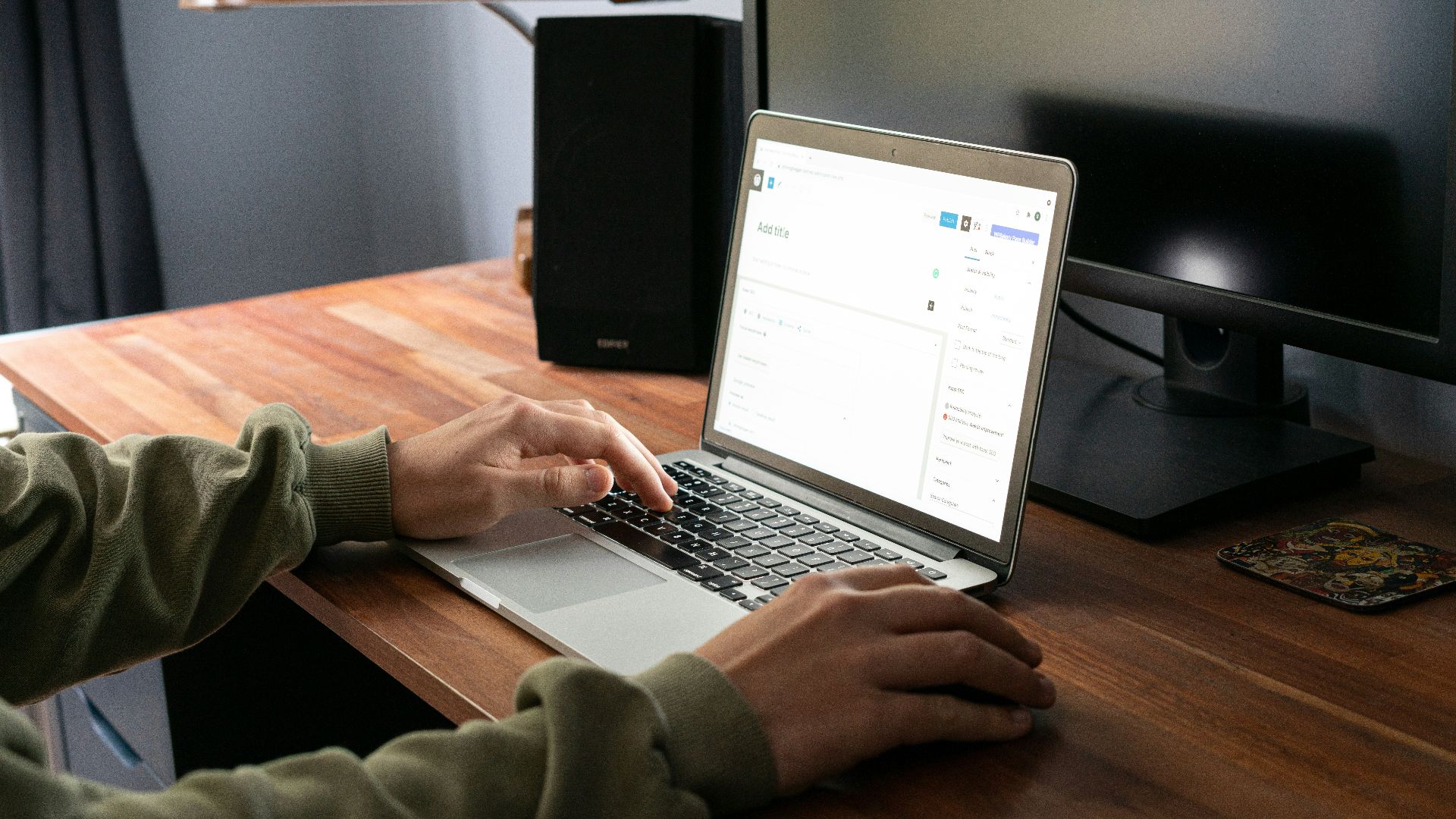 person using macbook pro on brown wooden table
