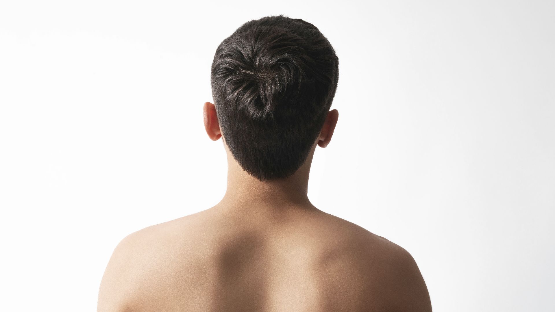 Back view of a young man's shoulders and head