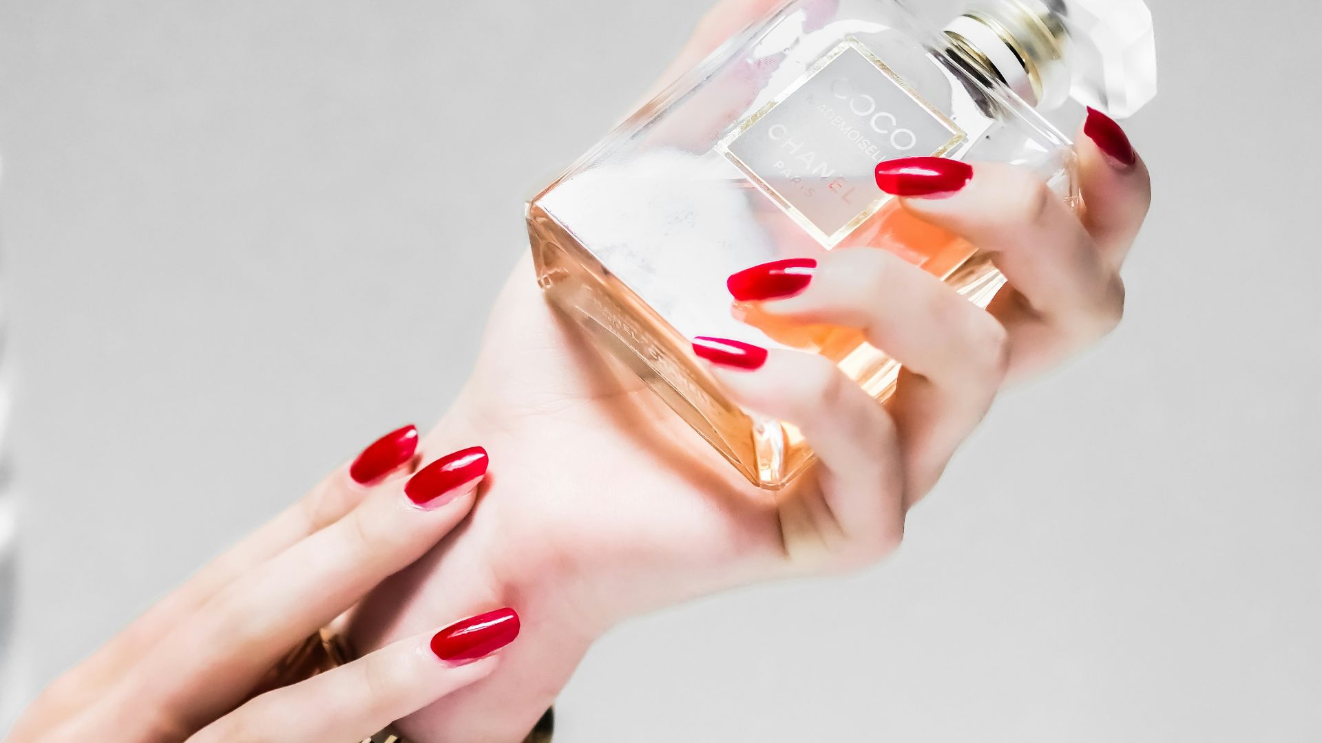 person holding clear glass bottle