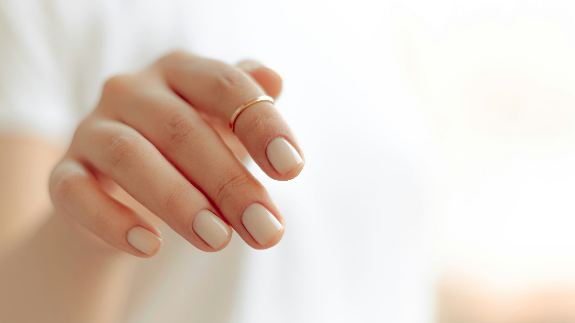 persons hand with white manicure
