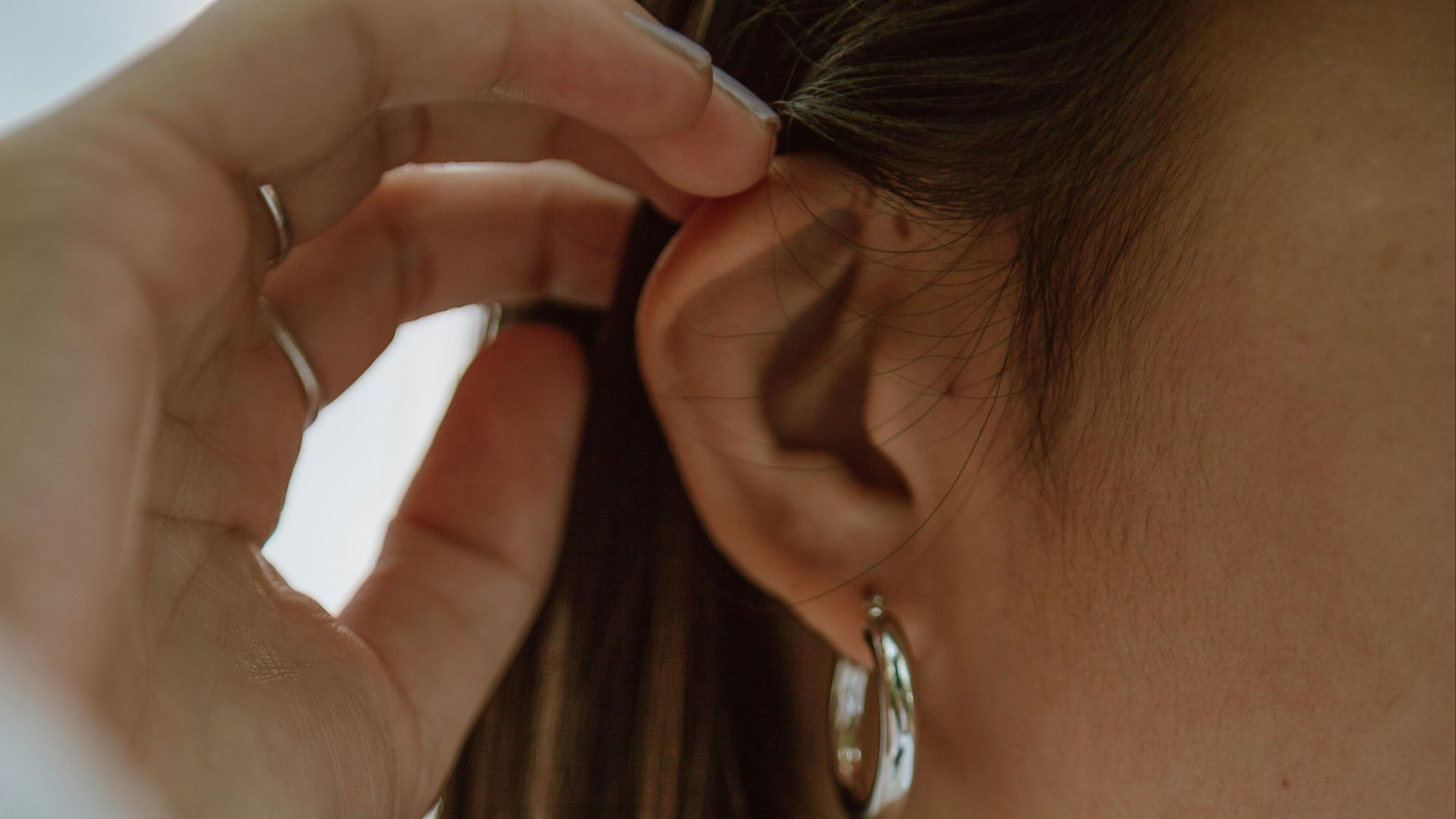 woman in white shirt wearing gold necklace
