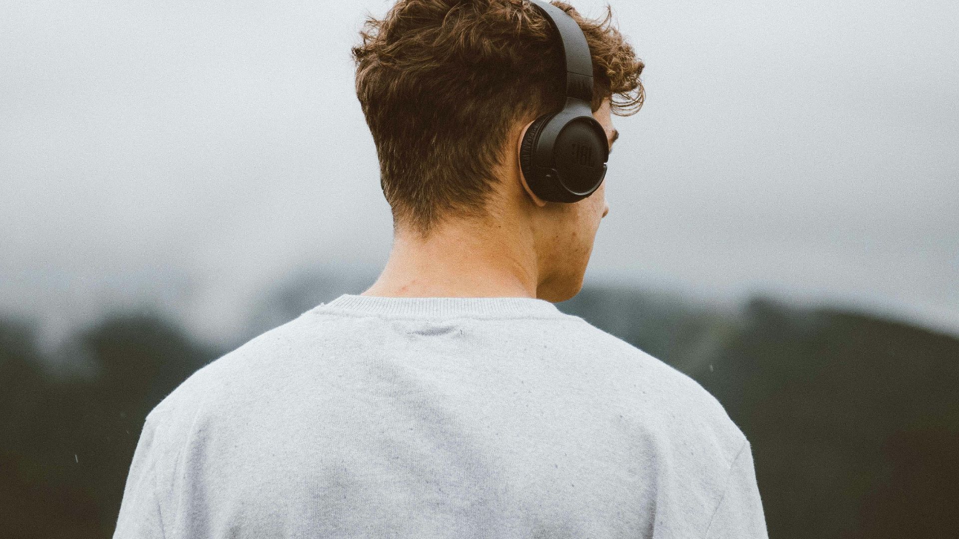 a man with headphones on looking at the mountains