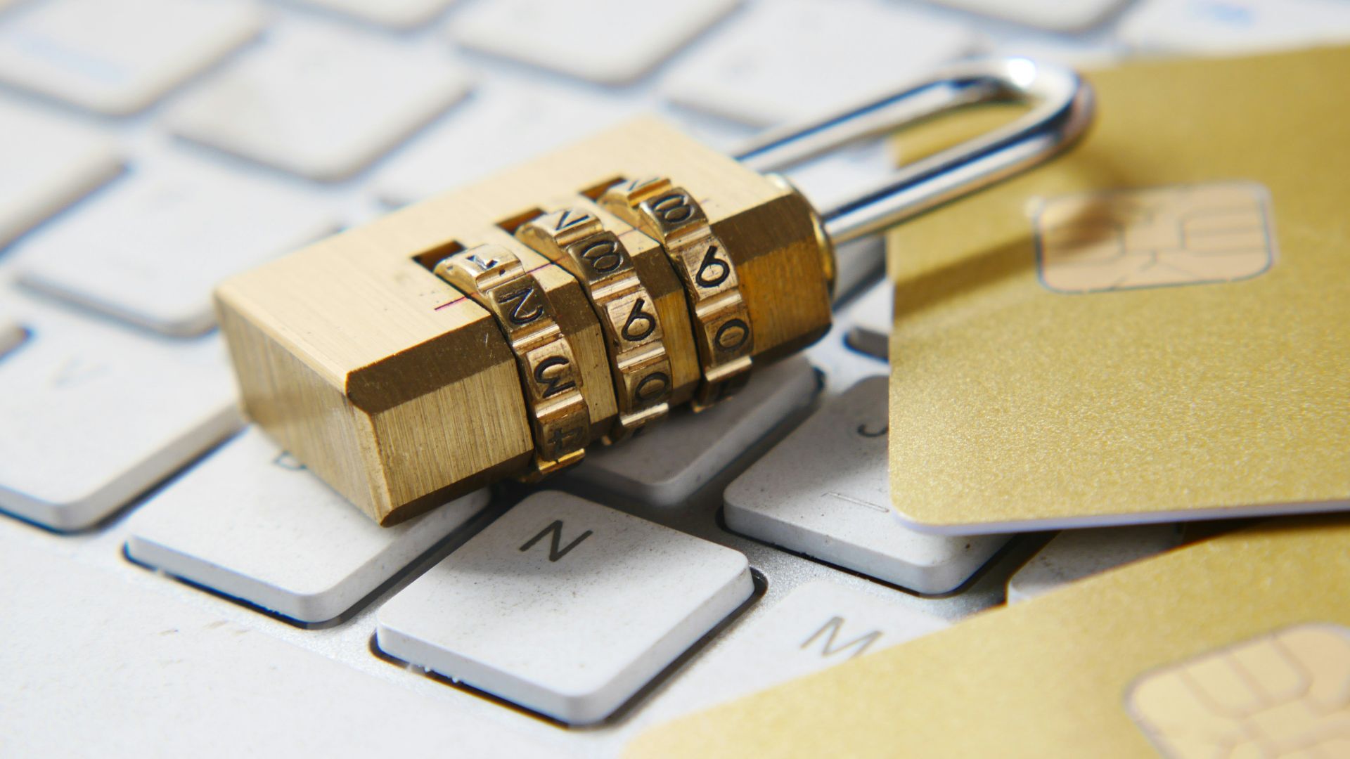 a golden padlock sitting on top of a keyboard