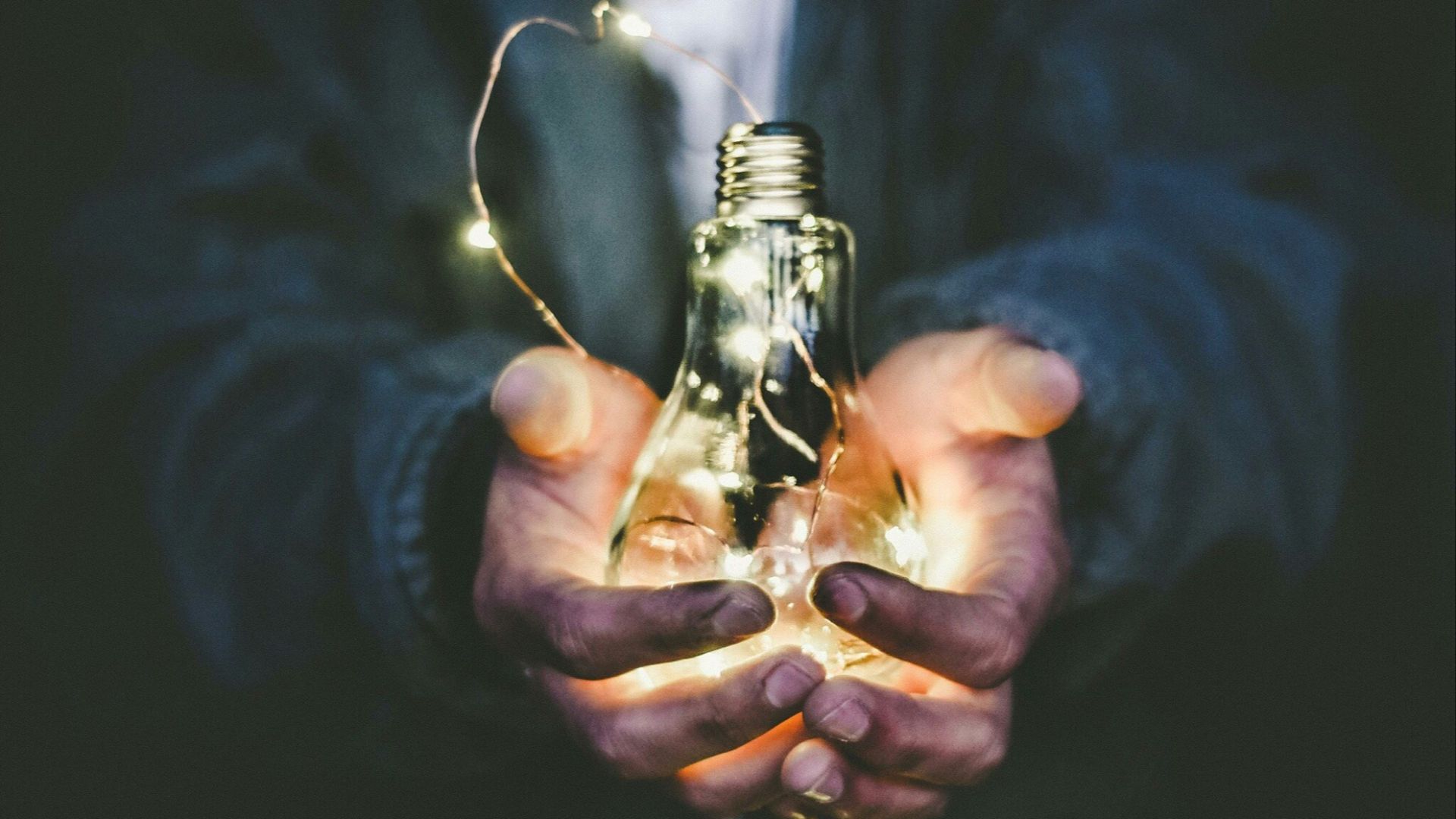 man holding incandescent bulb