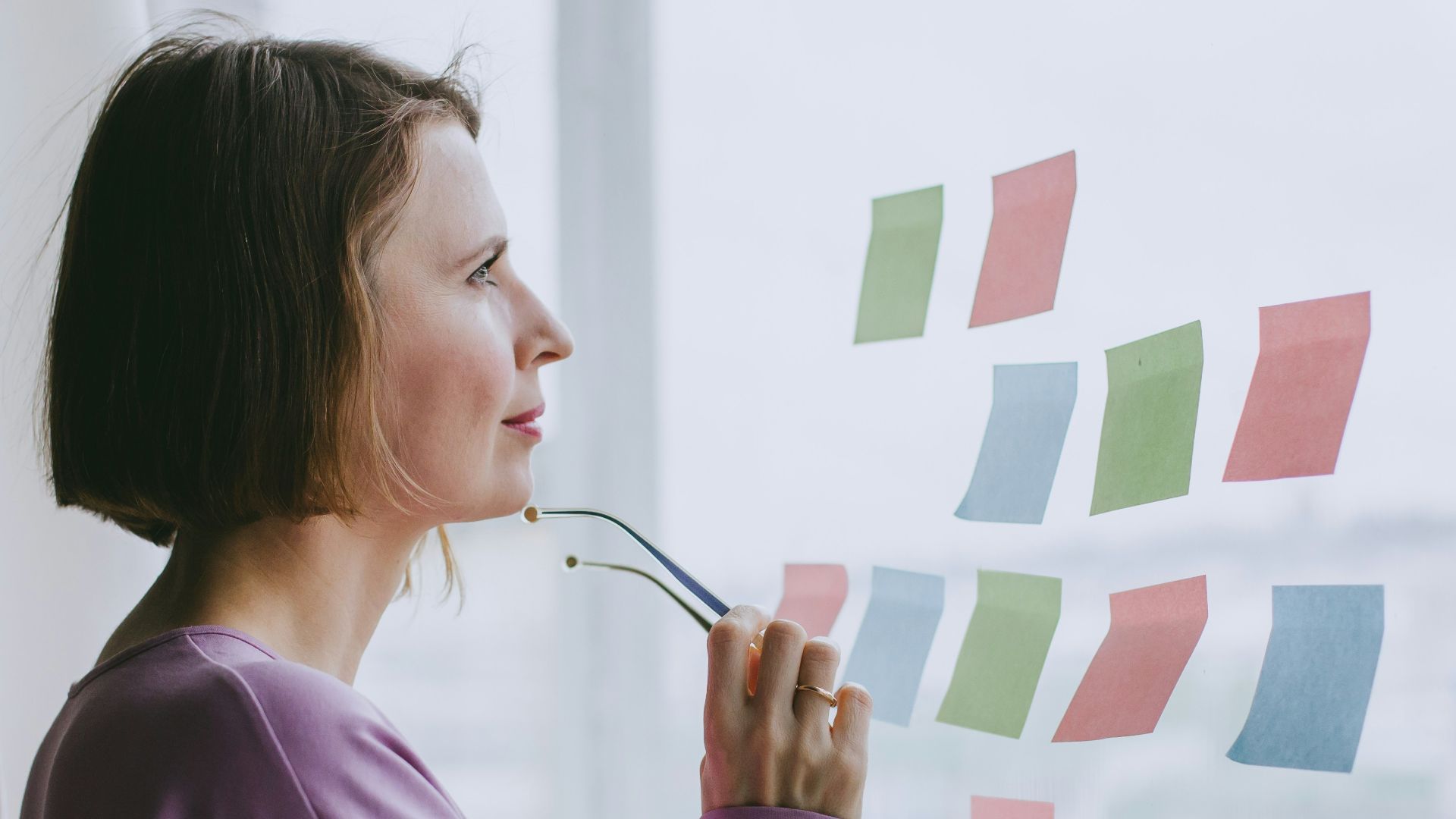 a woman looking out a window with sticky notes on it
