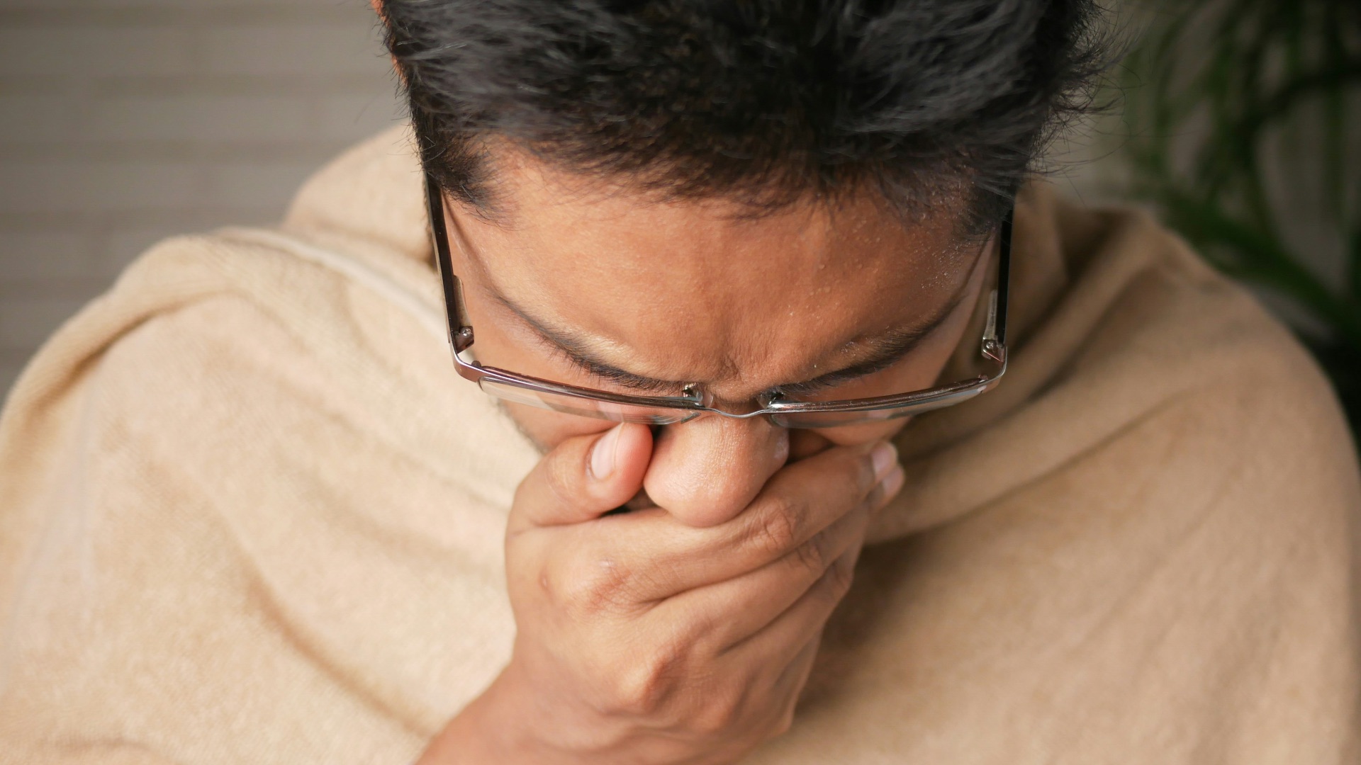 man in brown sweater wearing black framed eyeglasses