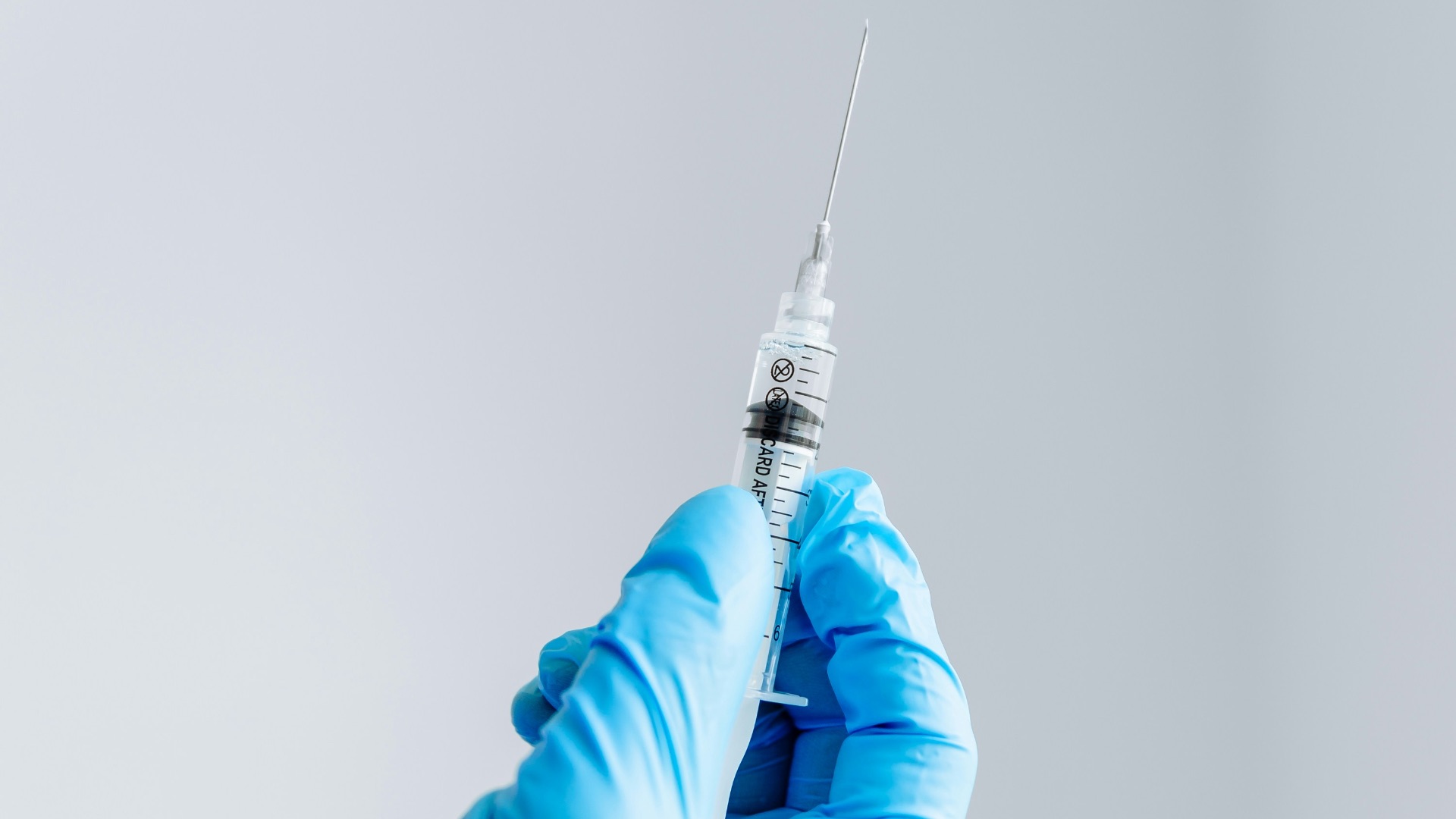 a hand in a blue glove holding a syquet