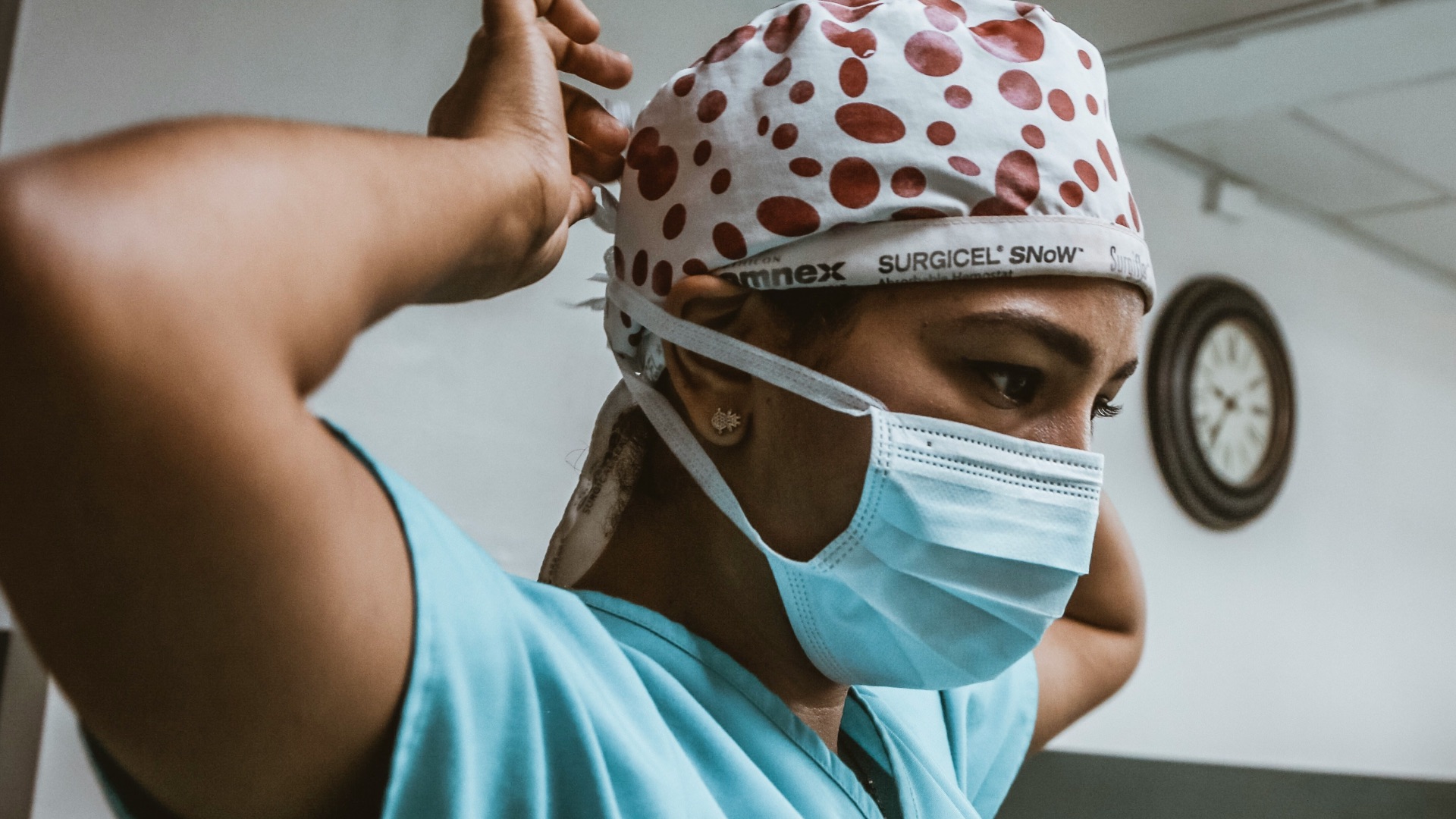 woman in teal shirt wearing white mask