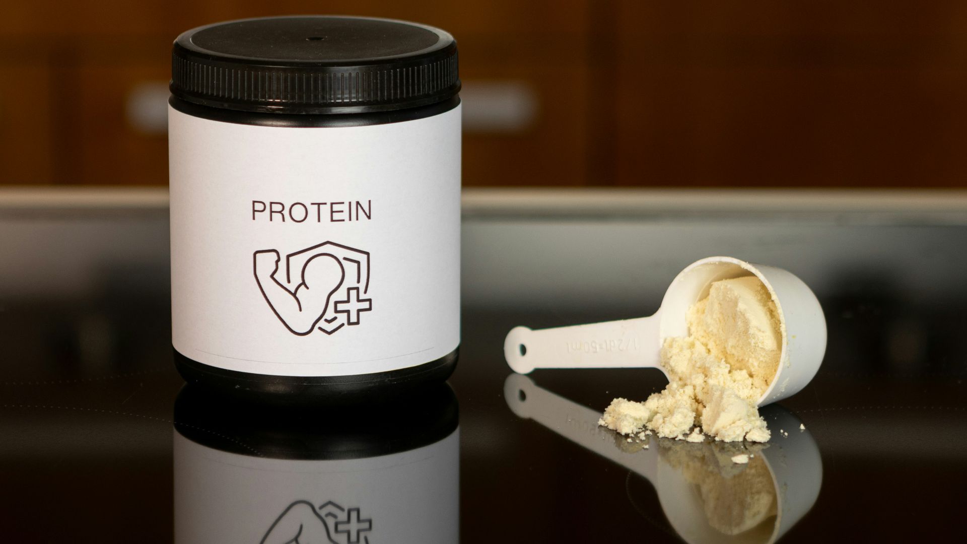 a container of protein powder next to a spoon