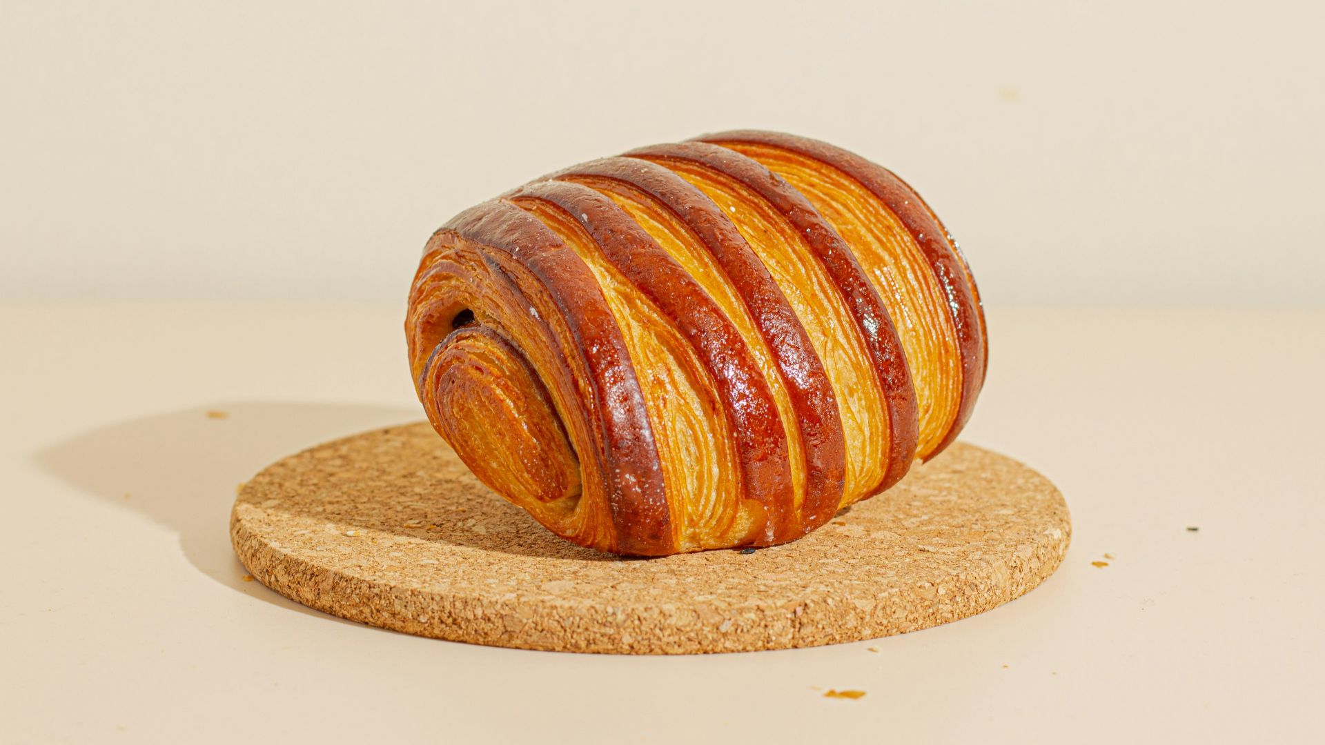 a piece of bread sitting on top of a cork coaster