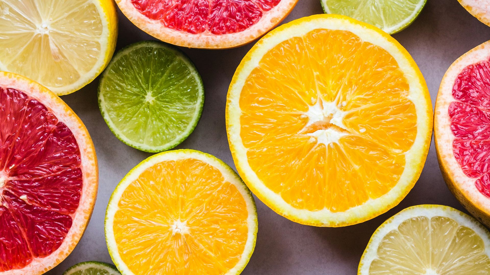 flat lay photography of sliced pomegranate, lime, and lemon
