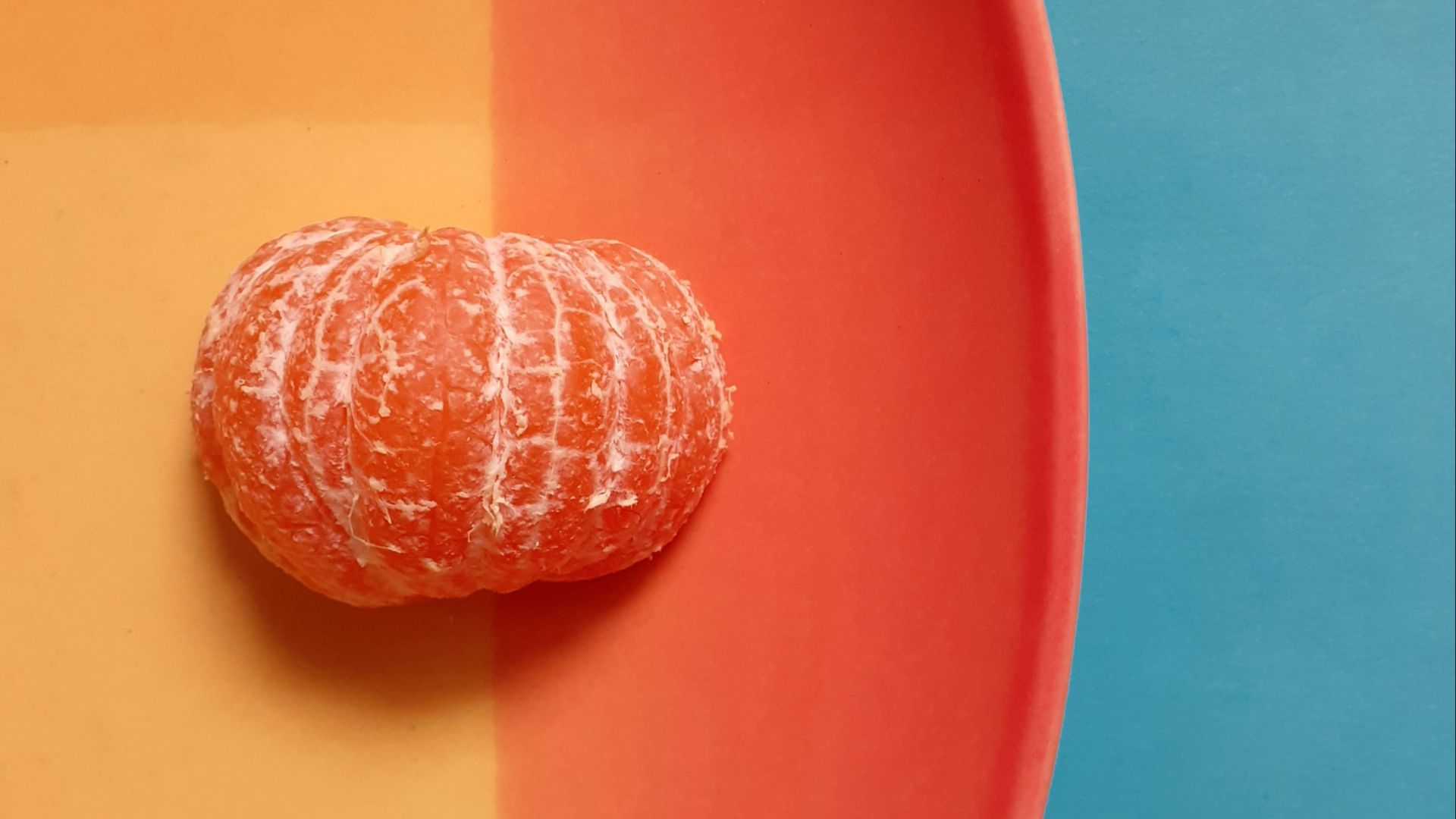 a peeled orange sitting on a plate on a table