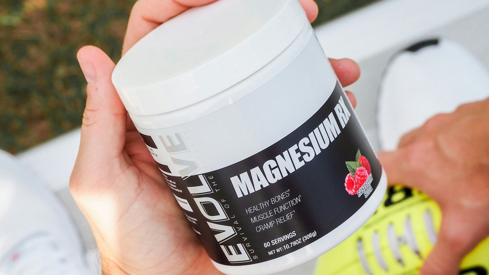 a man holding a jar of vitamin supplement