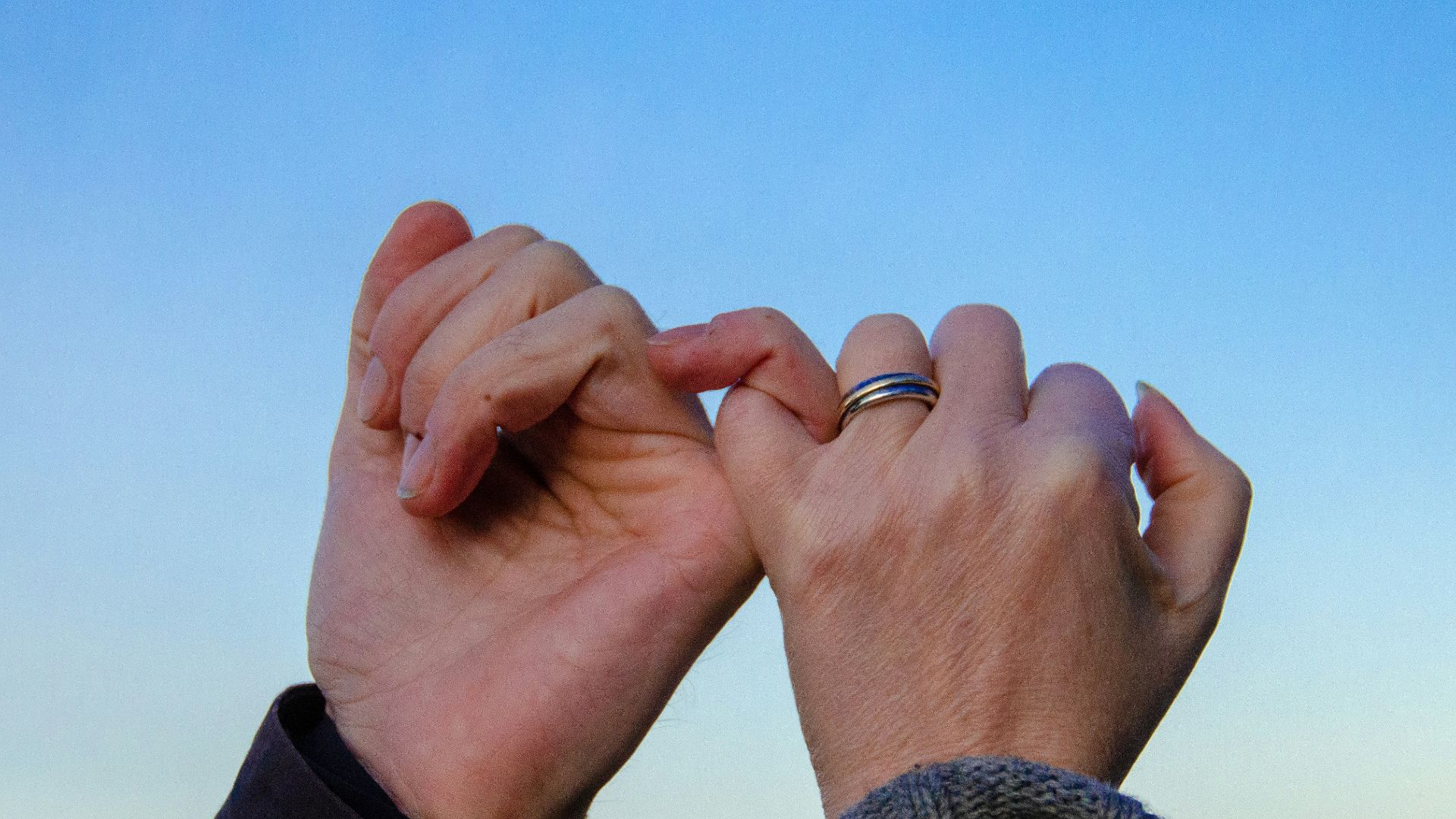 person in gray sweater with silver ring