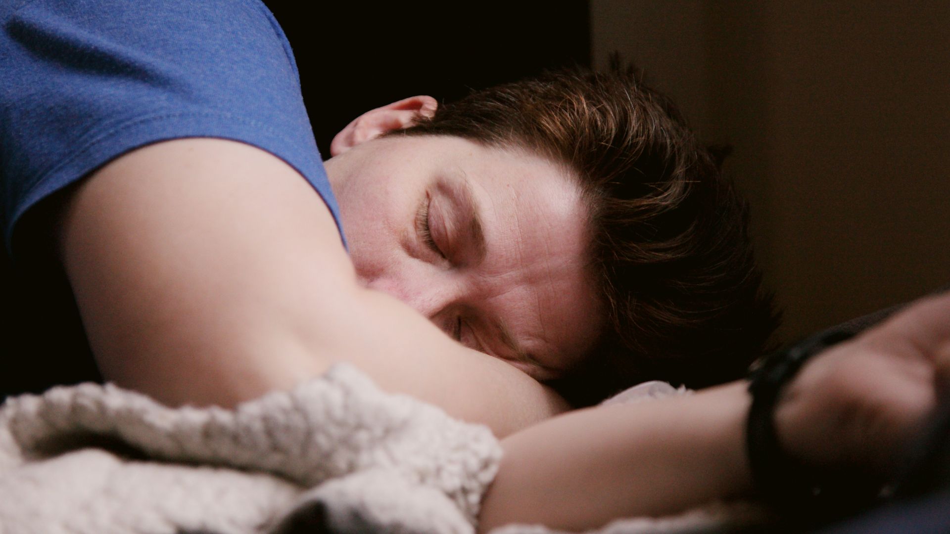 woman in blue shirt lying on bed