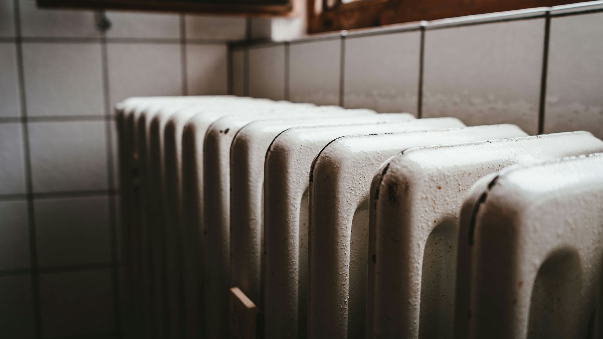 white radiator heater beside brown wooden window