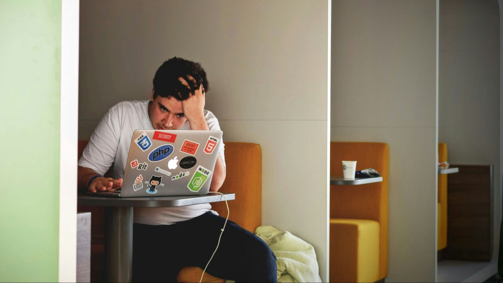 man wearing white top using MacBook