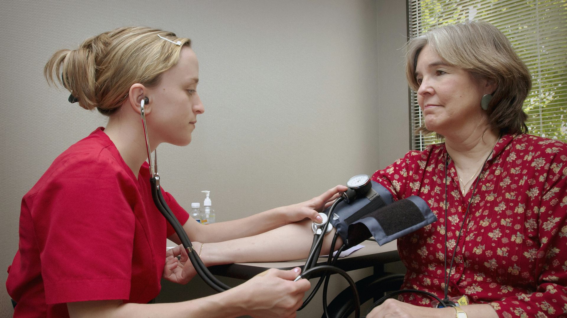 a woman with a stethoscope listening to a patient