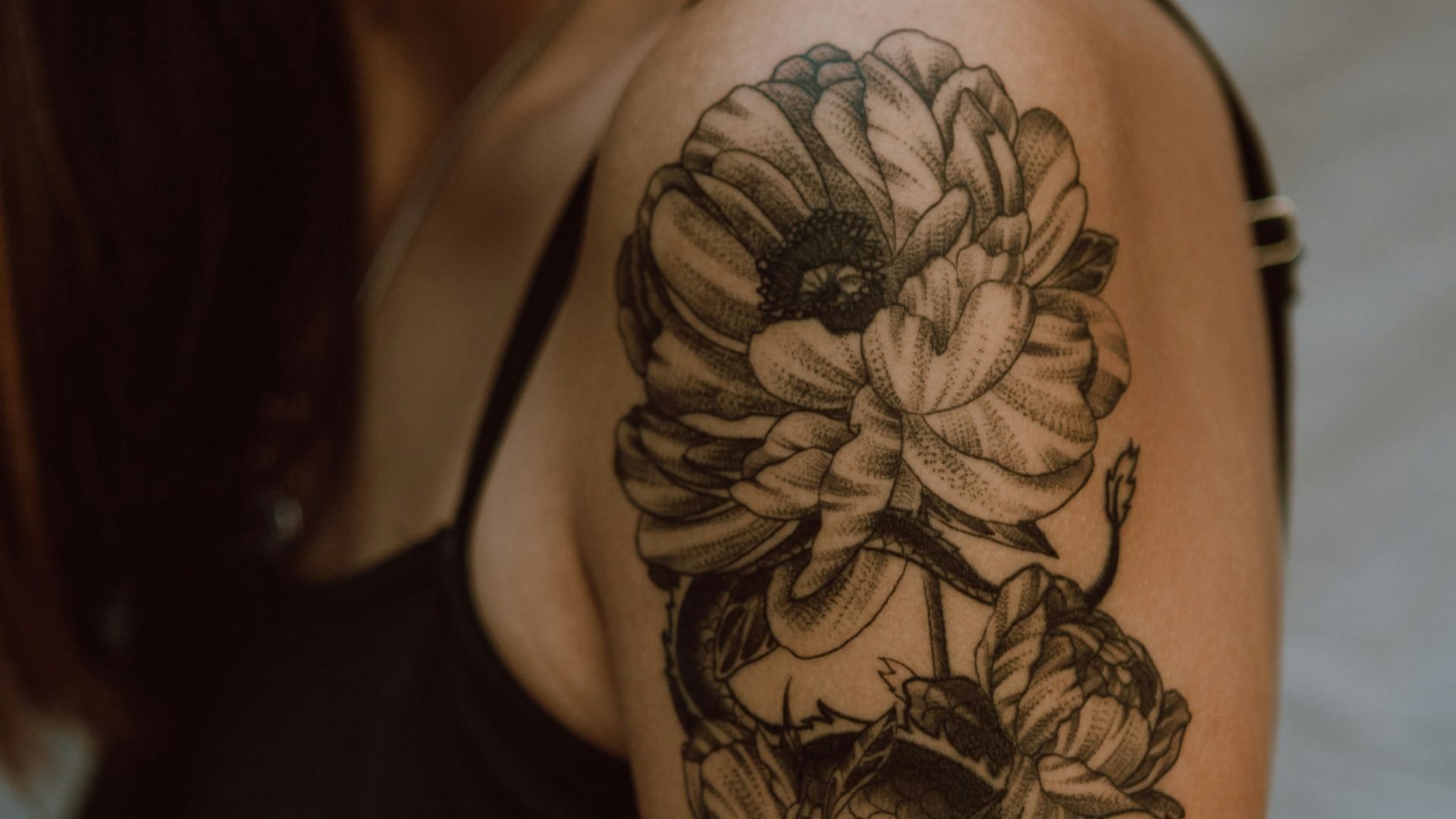 woman with black and brown floral tattoo on her back