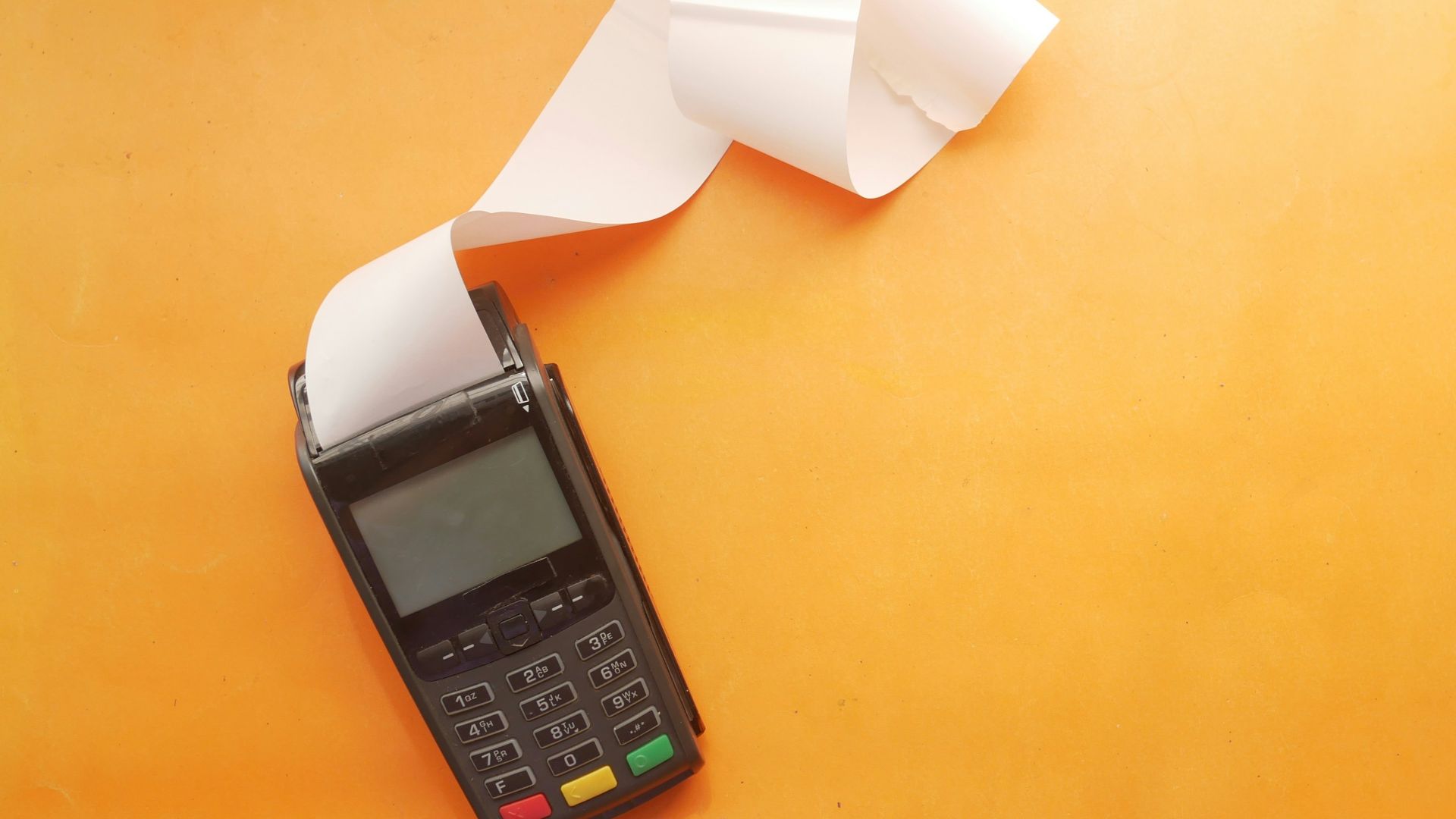 a cell phone sitting on top of a table next to a roll of paper