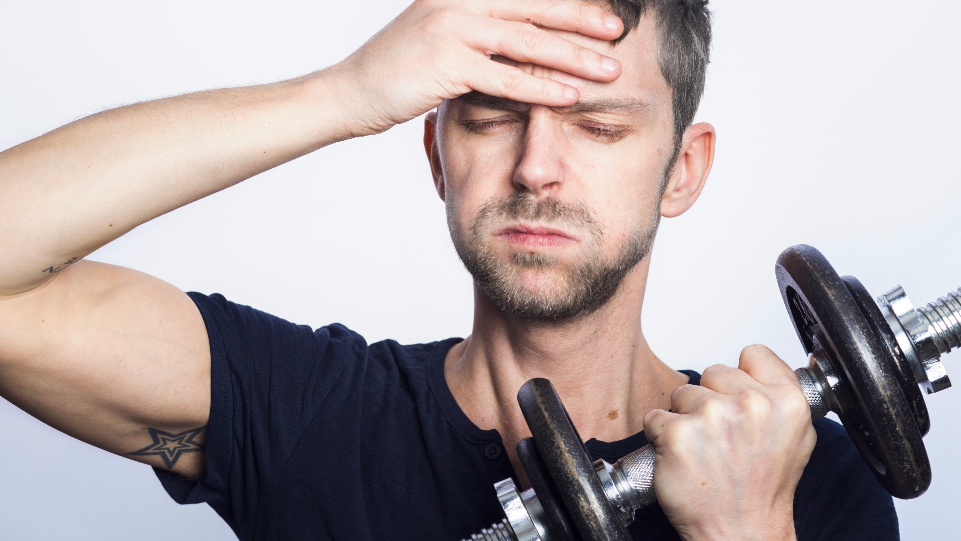 man in black crew neck t-shirt holding black dumbbell