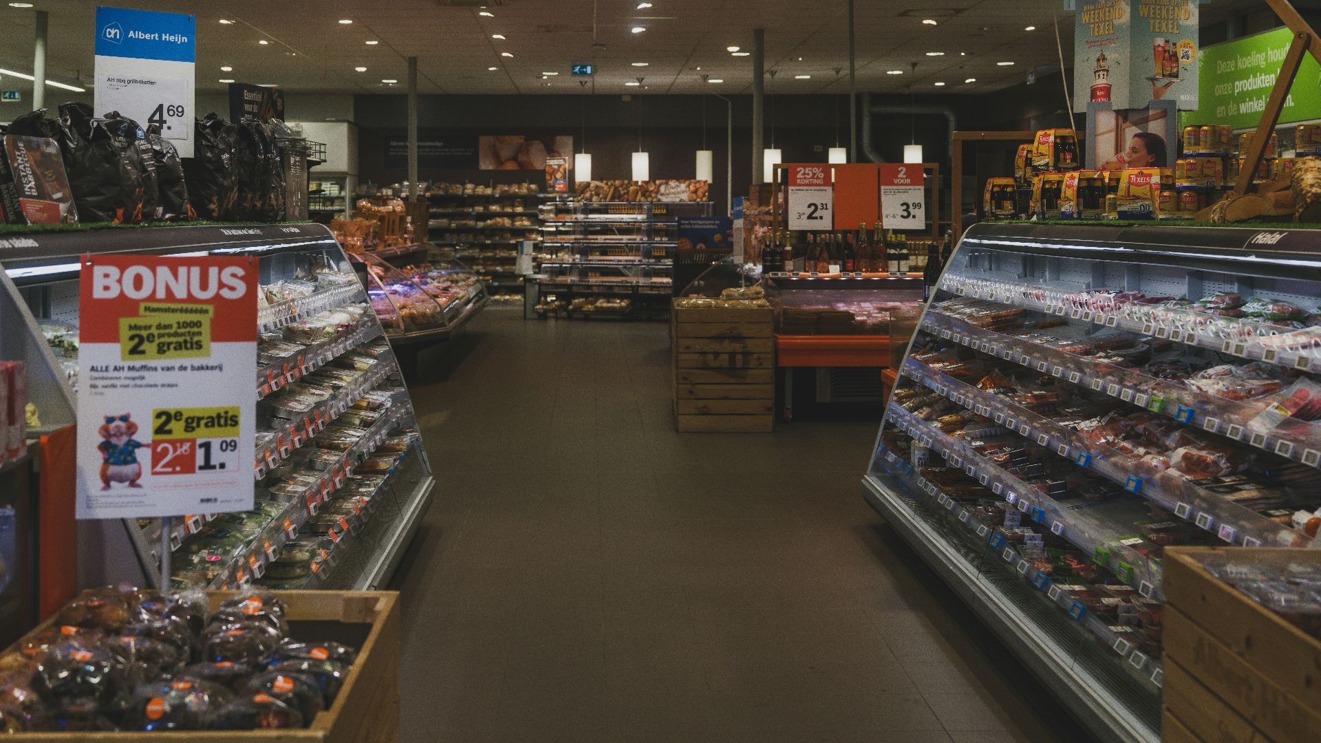 A grocery store aisle with refrigerated food displays.