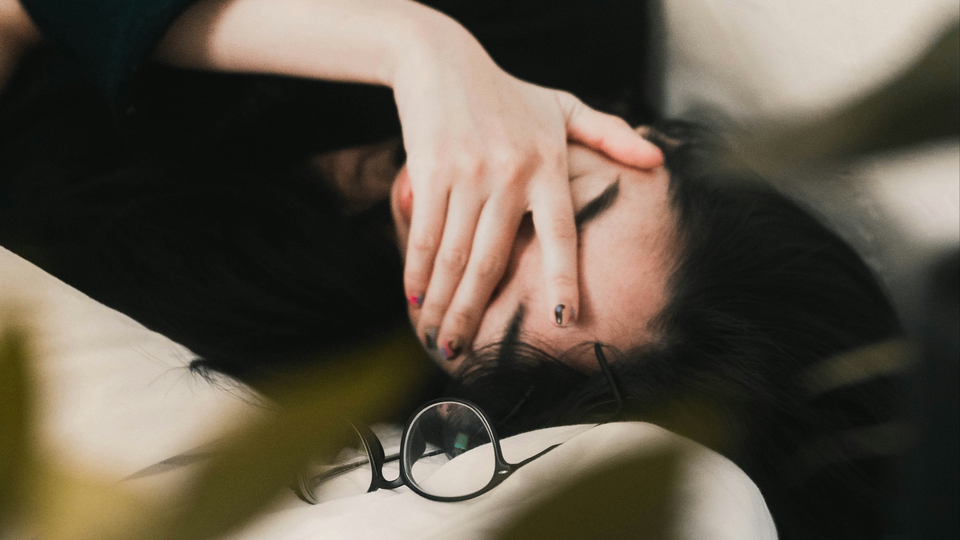 woman in black long sleeve shirt covering her face