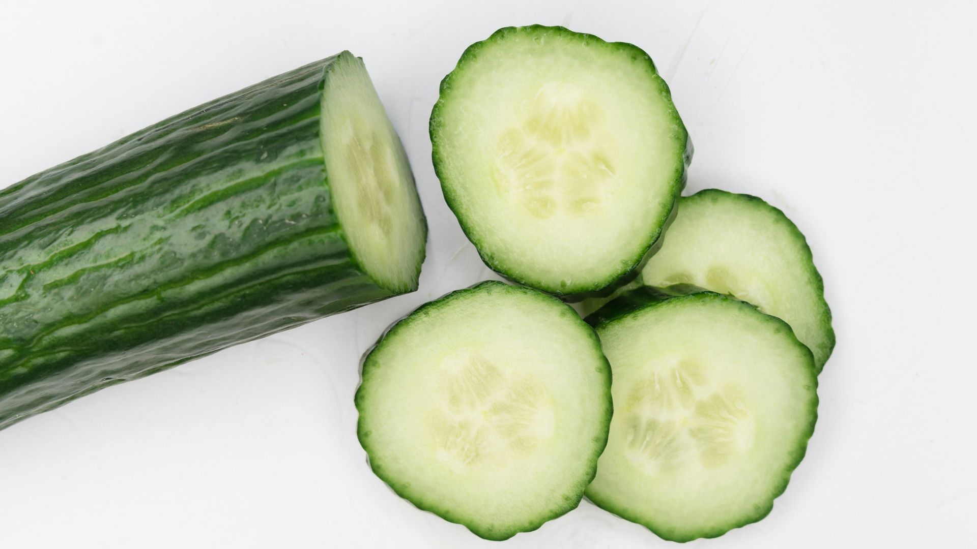 sliced cucumber on white surface