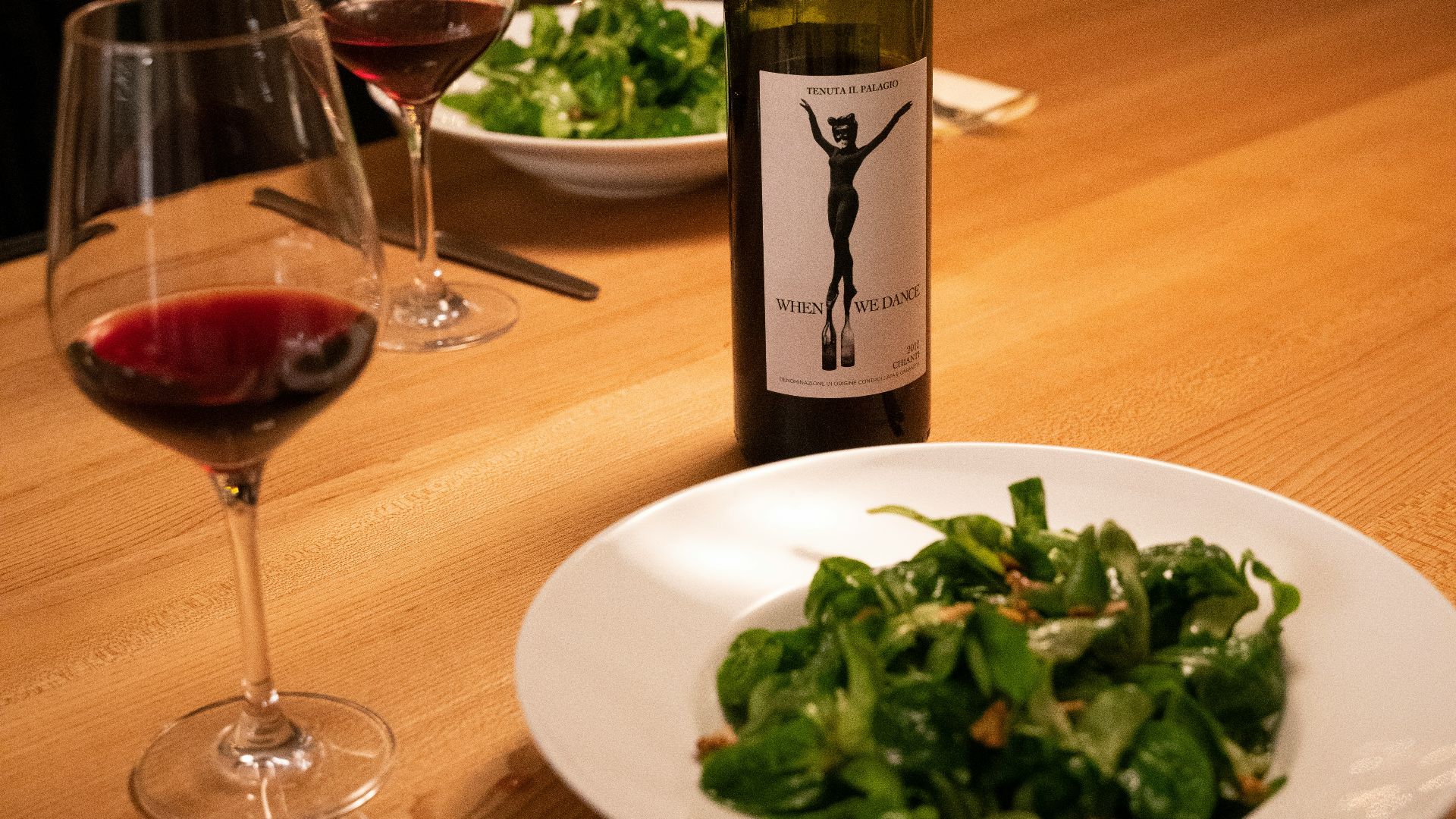 green wine bottle beside wine glass on table