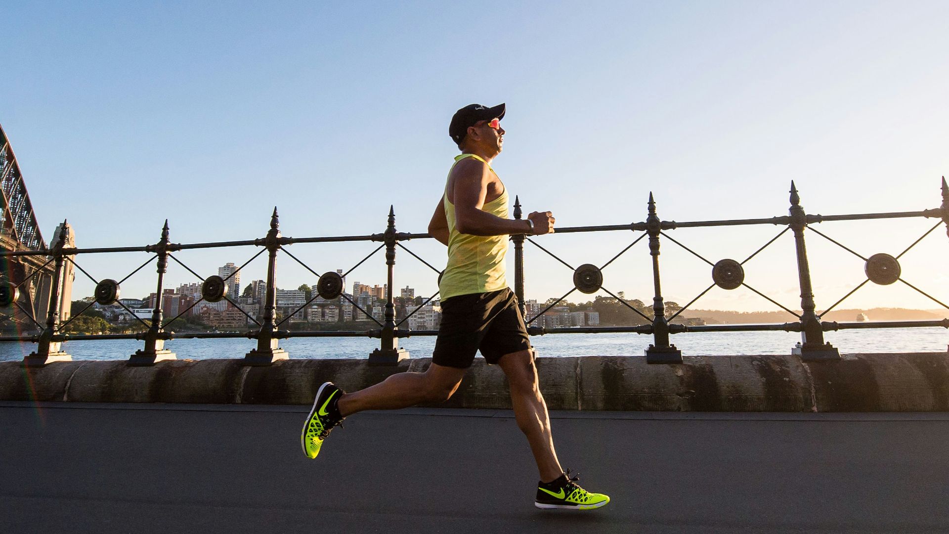 man in yellow tank top running near shore
