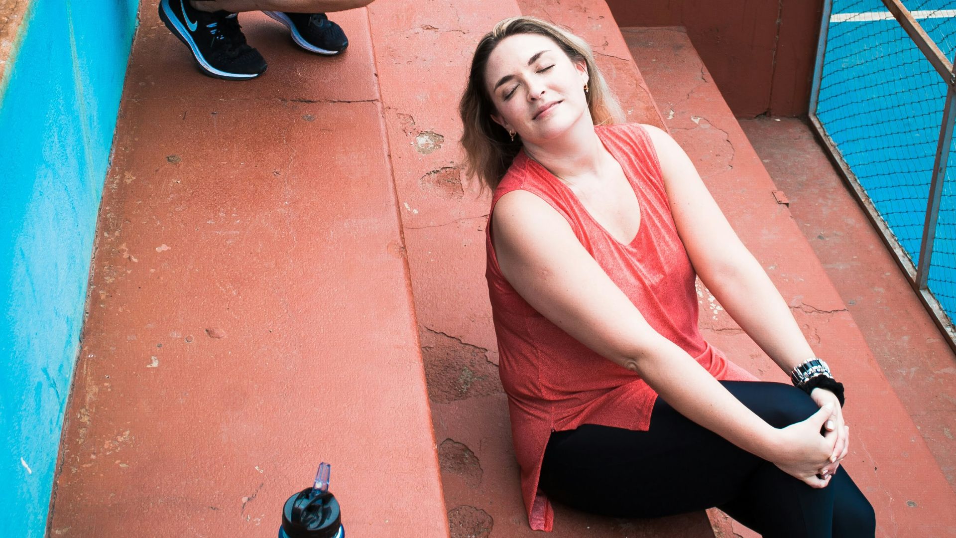 two women sitting on the steps talking on their cell phones